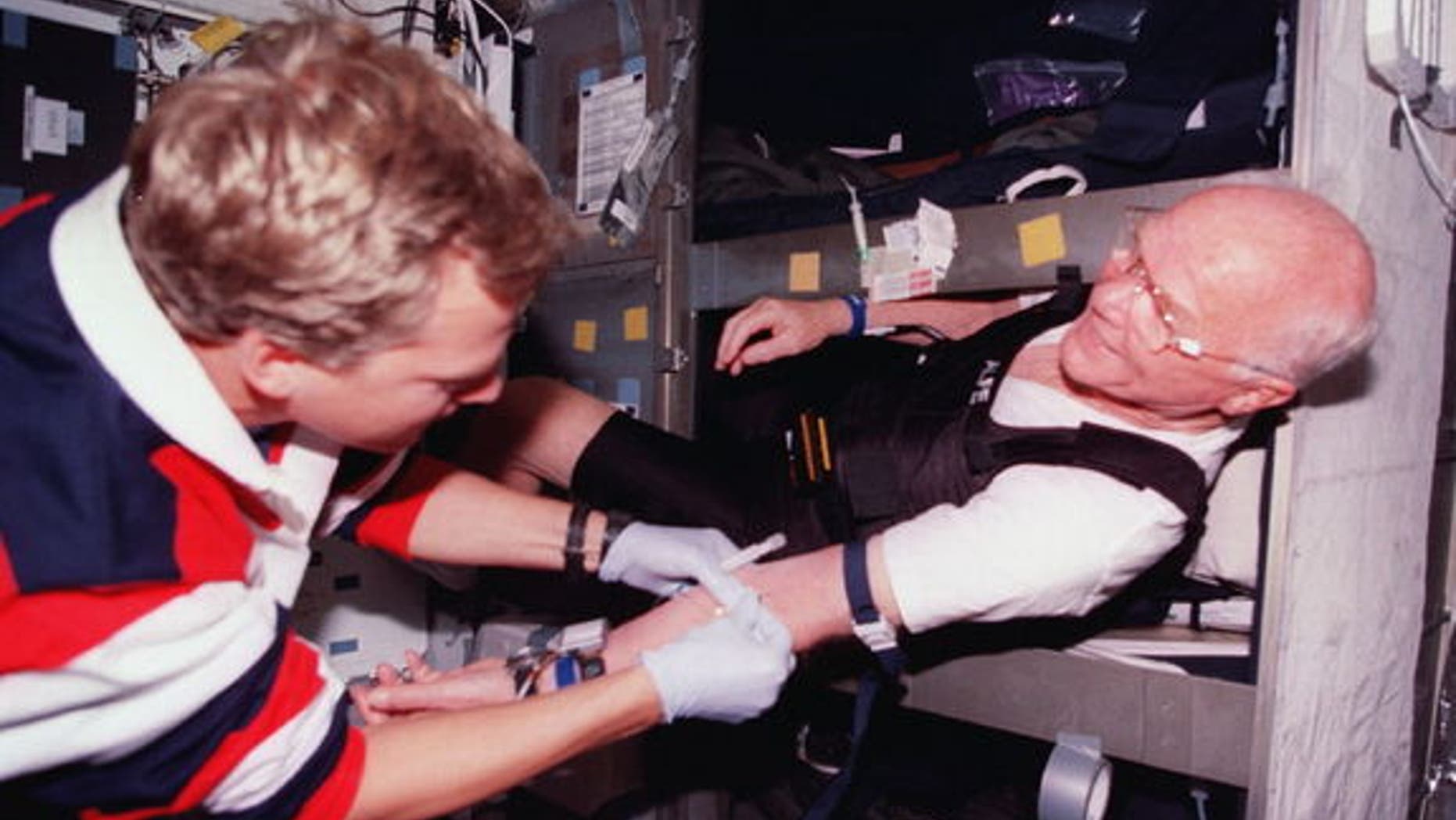 Astronaut John Glenn (right) gets bloodwork done in his bunk aboard space shuttle Discovery in 1998. About half of astronauts require sleep medication at some point during their flights, NASA said.