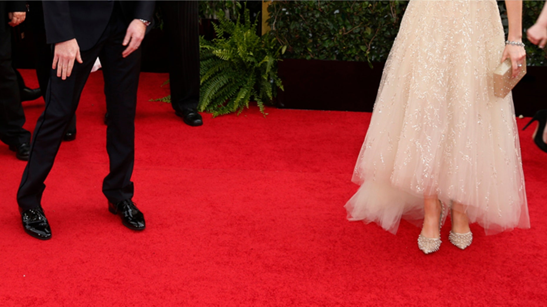 Actress Zooey Deschanel and actor Jesse Tyler Ferguson talk on the red carpet at the 71st annual Golden Globe Awards in Beverly Hills, California January 12, 2014. REUTERS/Danny Moloshok (UNITED STATES - Tags: Entertainment)(GOLDENGLOBES-ARRIVALS) - RTX17B5Z