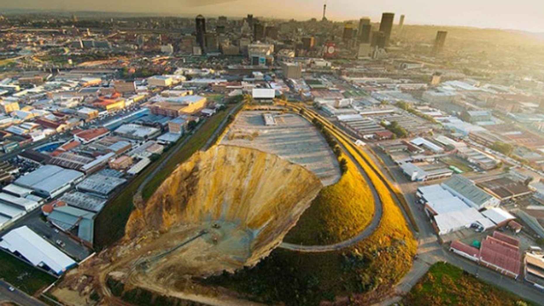 Johannesburg's landmark Top Star mine waste dump, shown here during the early stages of removal, once hosted a drive-in movie theater. Now it is gone, and the land reclaimed. (Courtesy: DRD Gold)