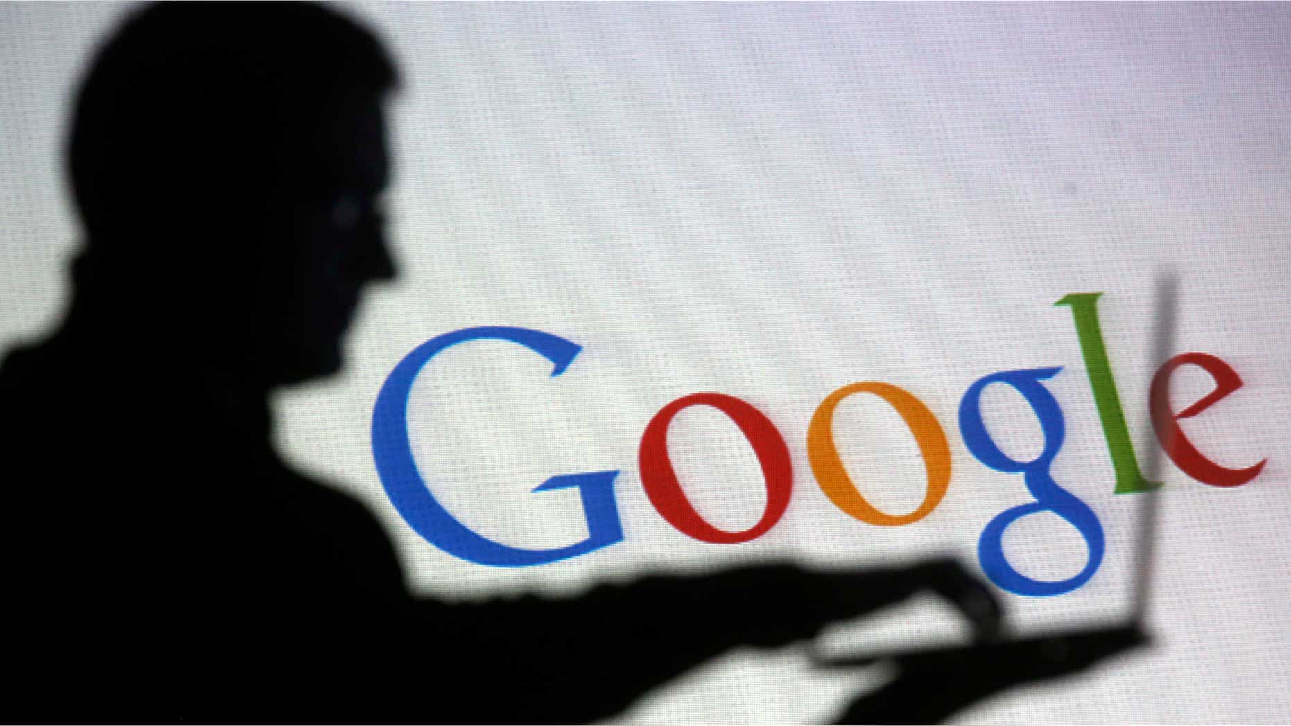Oct. 29, 2014: People are silhouetted as they pose with laptops in front of a screen projected with a Google logo, in this picture illustration taken in Zenica.