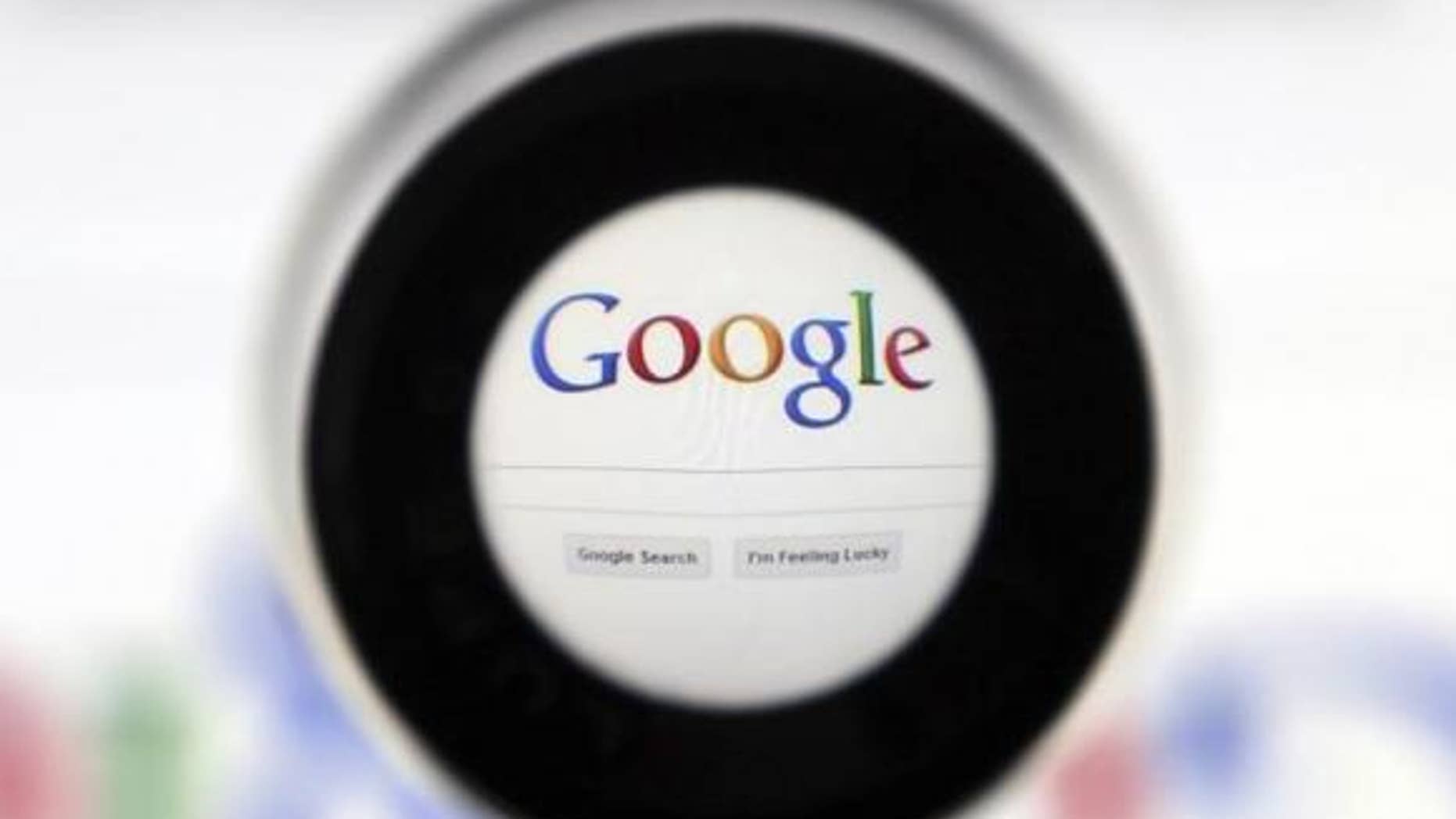 May 30, 2014: A file photo of a Google search page is seen through a magnifying glass in this photo illustration taken in Brussels.