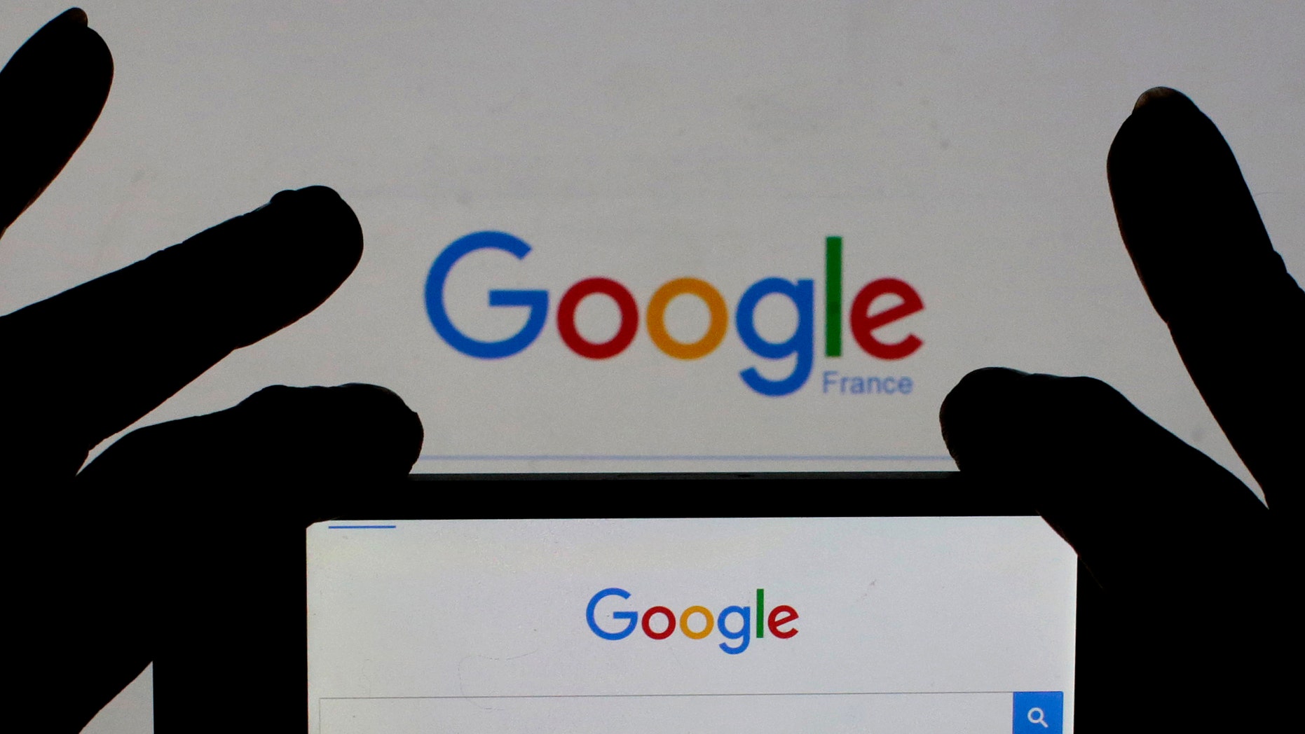 A woman holds her smart phone which displays the Google home page, in this picture illustration taken Feb. 24, 2016. (REUTERS/Eric Gaillard/Illustration)