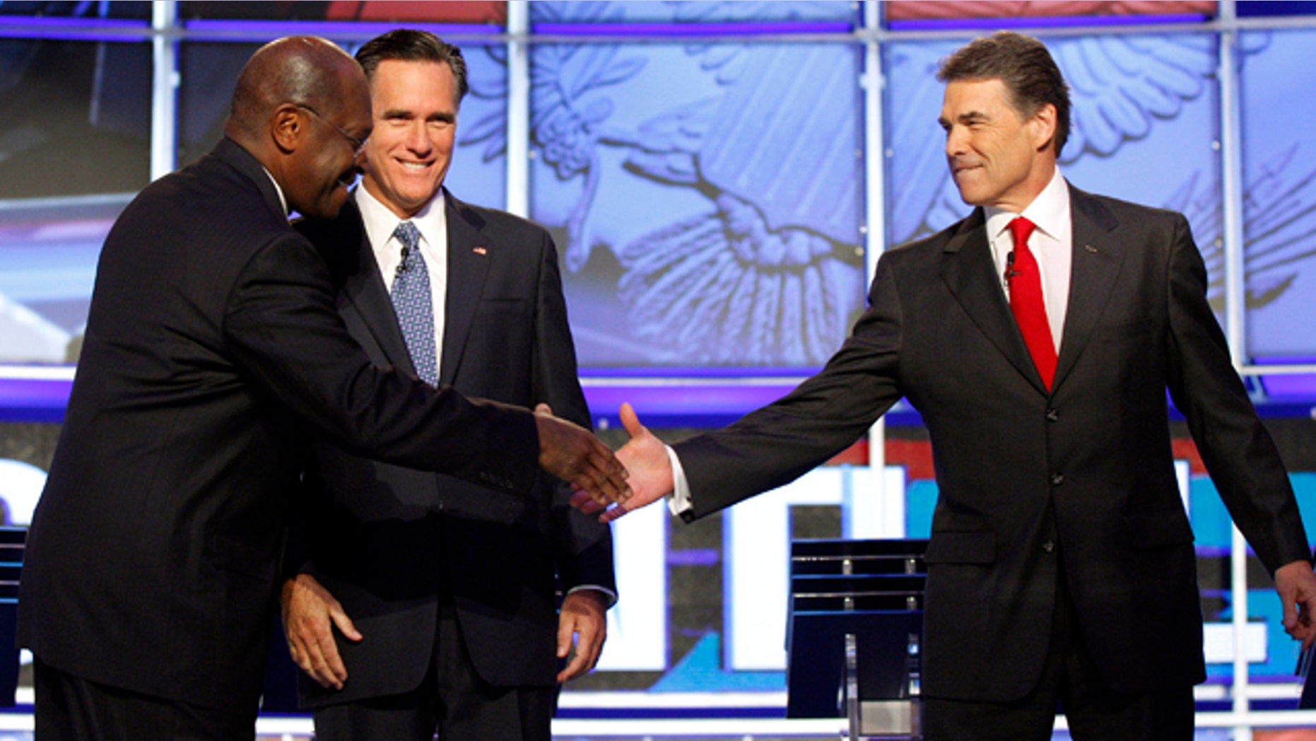 Oct. 18, 2011: Republican presidential candidates Herman Cain, left, shakes hands with Texas Gov. Rick Perry as former Massachusetts Gov. Mitt Romney looks on before a Republican presidential debate in Las Vegas.