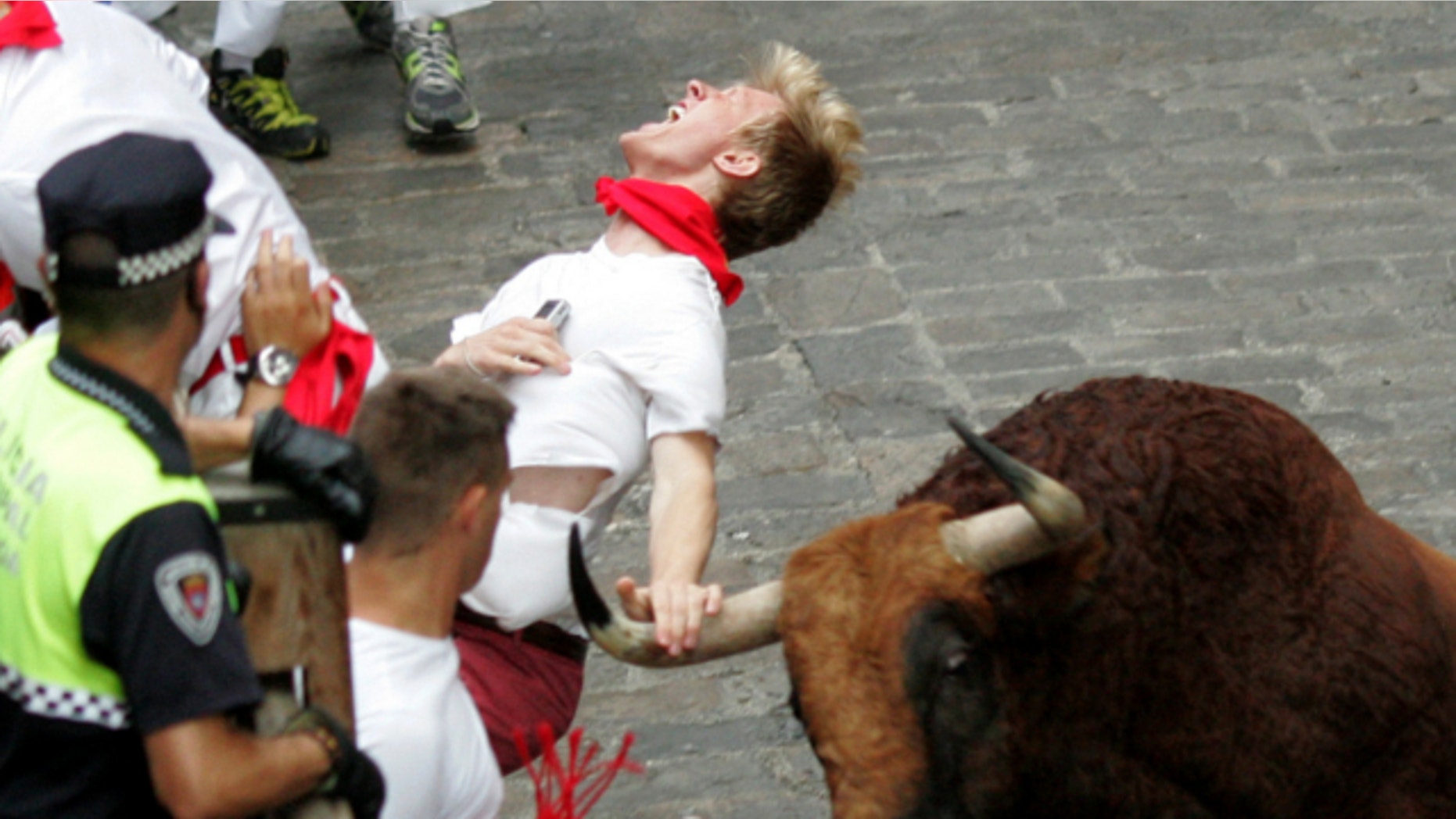 July 12, 2013: A runner is gored by an "El Pilar" fighting bull during the running of the bulls at the San Fermin festival, in Pamplona, Spain.