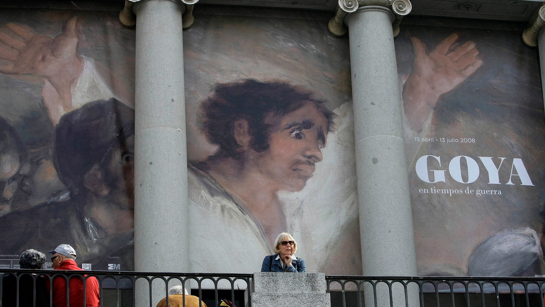 File photo - People sit in front of a banner announcing an exhibition by Spanish legendary artist Francisco Goya at Madrid's El Prado museum in Madrid April 15, 2008. (REUTERS/Andrea Comas)