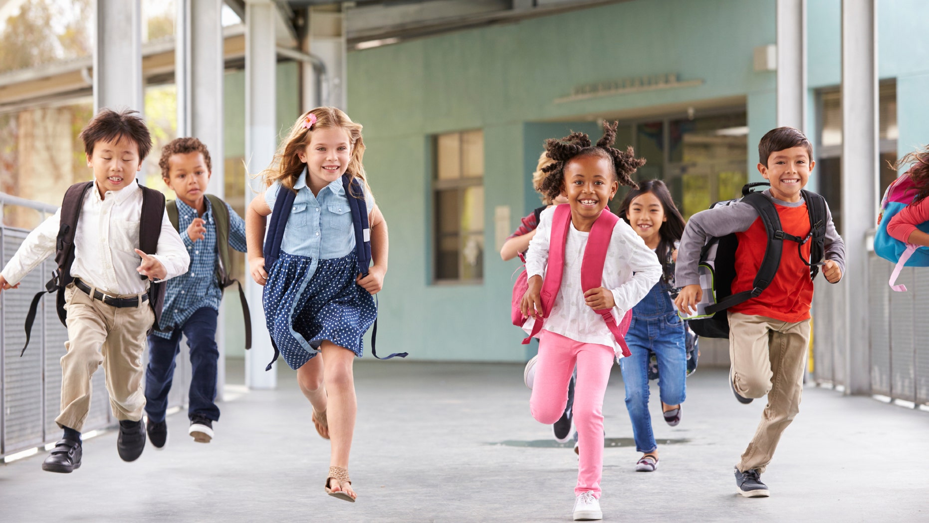 Group of elementary school kids running in a school corridor
