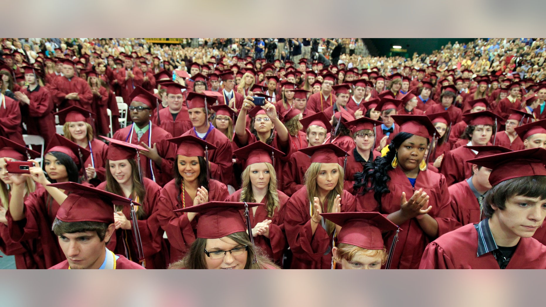 JOPLIN, MO - MAY 21: Graduating seniors of Joplin High School applaud U.S. President Barack Obama after his speech Monday night during the Joplin High School Commencement Ceremony for the Class of 2012 at the Missouri Southern State University Leggett & Platt Athletic Center on May 21, 2012 in Joplin, Missouri. President Barack Obama spoke at the event in commemoration of the one year anniversary of the city being struck by an EF-5 tornado. (Photo by Rich Sugg-Pool/Getty Images)