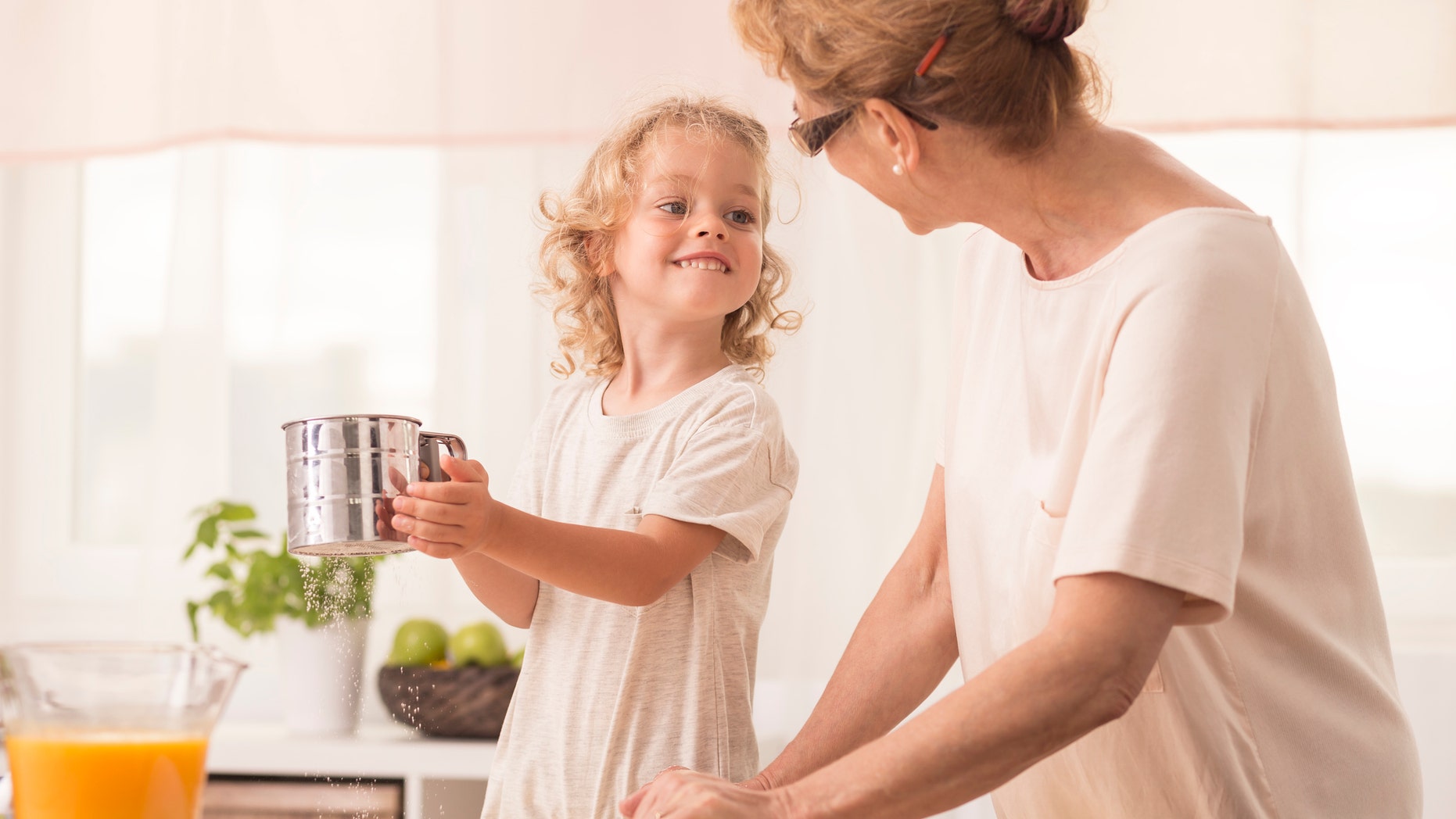 Happy small grandson and his garndmother baking together