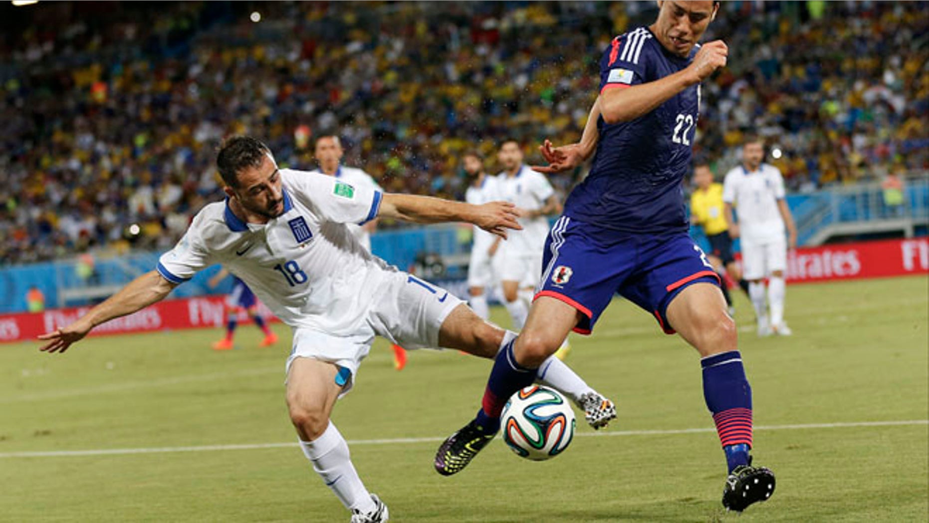 June 19, 2014: Greece's Giannis Fetfatzidis, left, challenges Japan's Maya Yoshida during the group C World Cup soccer match between Japan and Greece at the Arena das Dunas in Natal, Brazil.