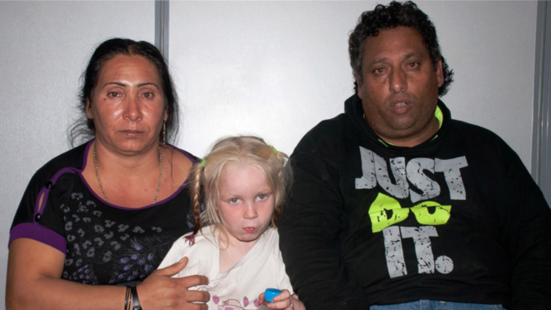Oct. 17, 2013: In this police handout photo Christos Salis, 39, right, and his companion Eleftheria Dimopoulou, 40, or Selini Sali as the woman has two separate sets of identity papers, pose with the little girl only known as "Maria" in the Larisa regional police headquarters, Greece.