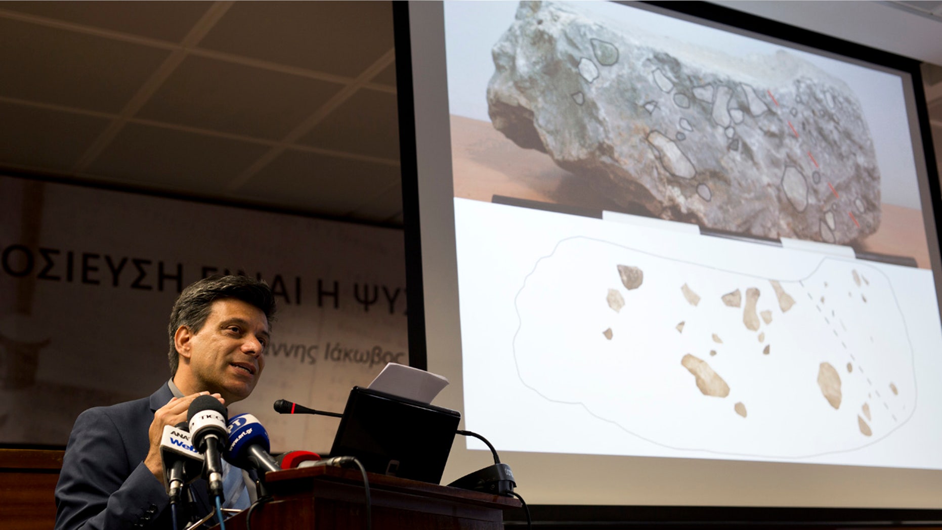 June 14, 2016: Greek archaeologist Christofilis Maggidis speaks as a photograph of a stone he believes belonged to the lost royal throne in the ancient palace of Mycenae, heart of the Mycenaean civilization, in southern Greece, during a press conference in Athens.