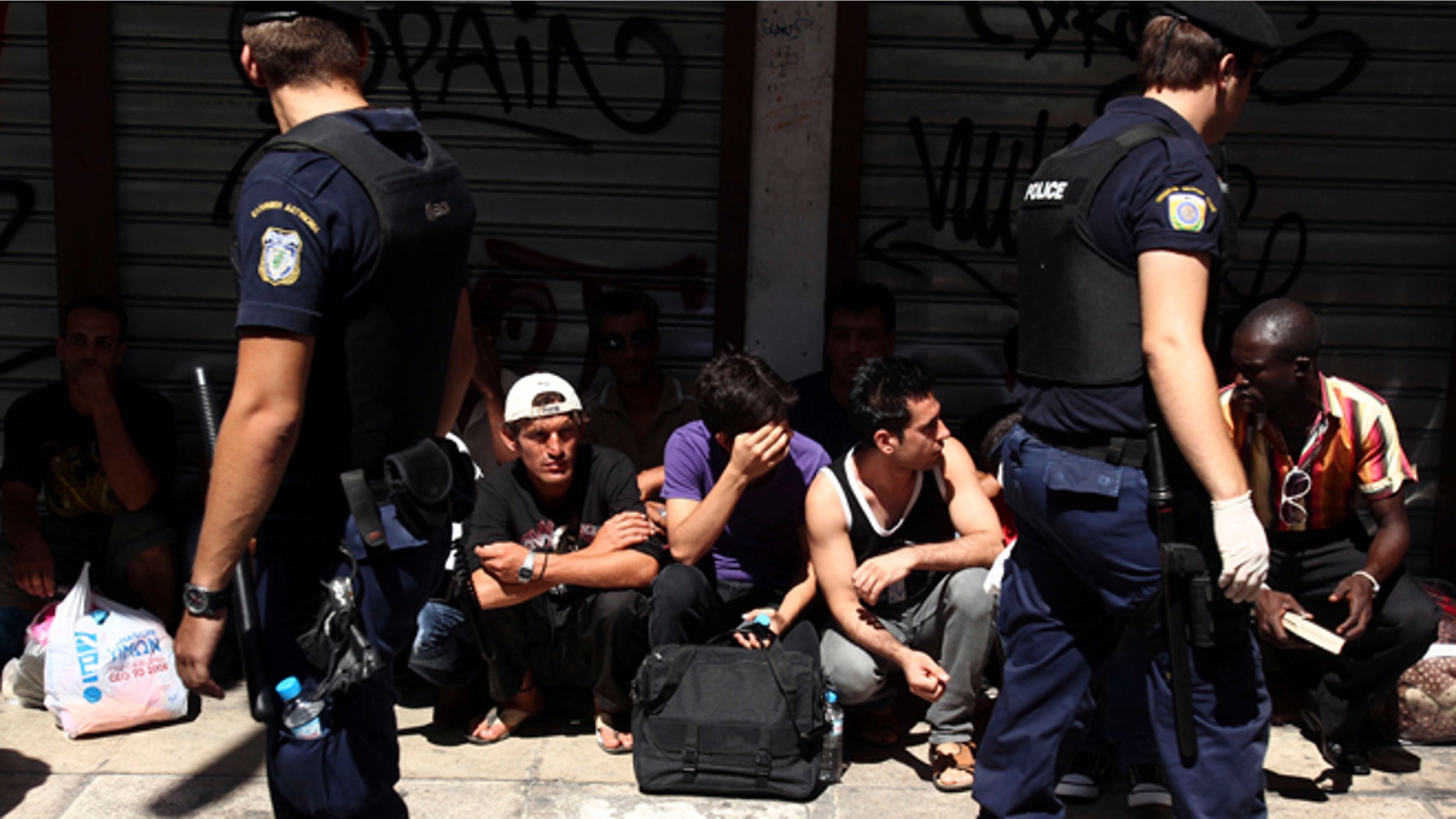 August 5, 2012: Police detain a group of migrants in central Athens.