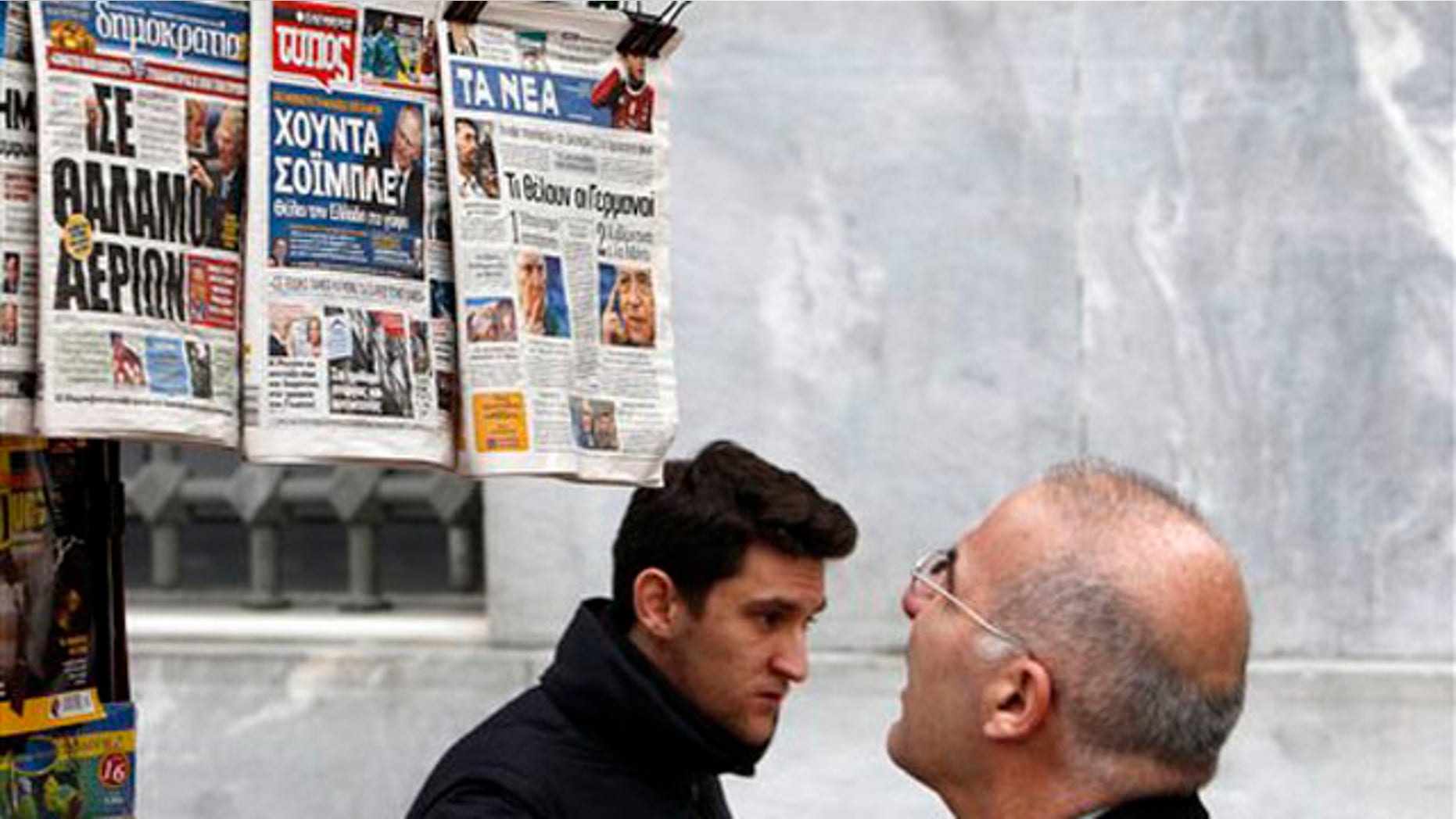 Feb. 16, 2012: A man reads the front pages of three Greek newspapers in Athens. Mounting confusion over whether Greece will get vital bailout cash to avoid defaulting next month is rekindling fears that Europe's debt crisis will spread to bigger countries like Italy.