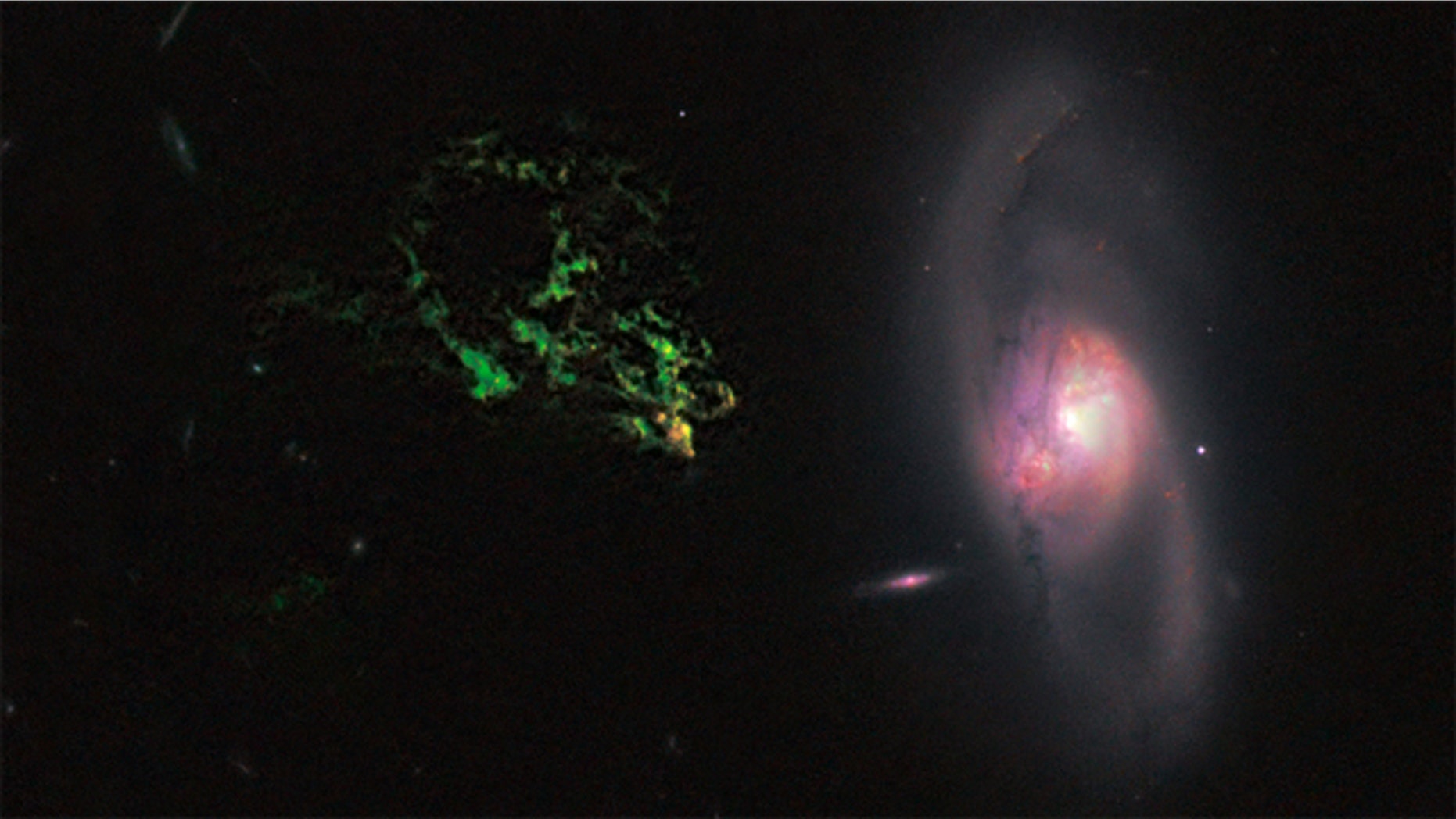 In this image by NASA's Hubble Space Telescope, an unusual, ghostly green blob of gas appears to float near a normal-looking spiral galaxy. The bizarre object, dubbed Hanny's Voorwerp (Hanny's Object in Dutch), is the only visible part of a 300,000-light-year-long streamer of gas stretching around the galaxy, called IC 2497.