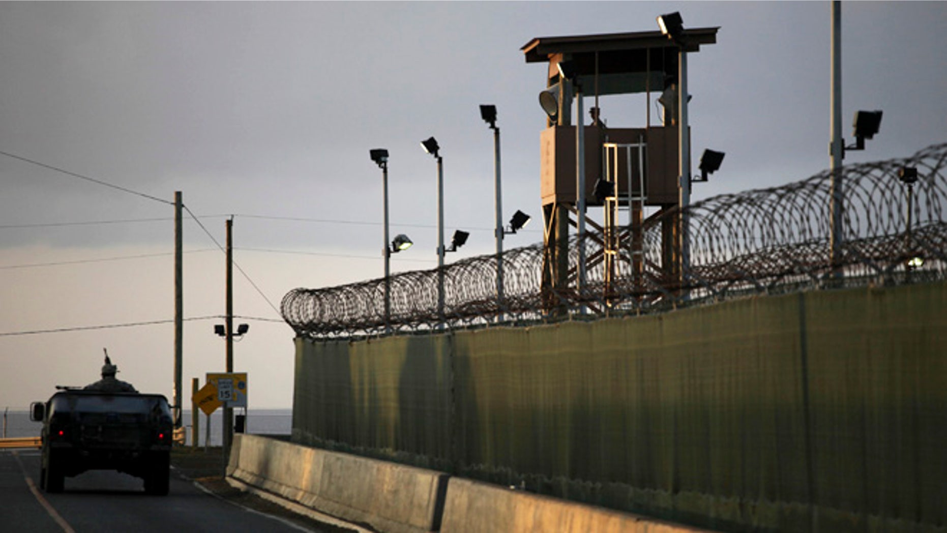 In this March 30, 2010 file photo, reviewed by the U.S. military, a U.S. trooper stands in the turret of a vehicle with a machine gun, left, as a guard looks out from a tower at the detention facility of Guantanamo Bay U.S. Naval Base in Cuba. The U.S. government has dropped its opposition to the release of a Guantanamo Bay prisoner, Ibrahim Idris, who suffers from severe psychological and physical illnesses. He will likely go back to his native Sudan.