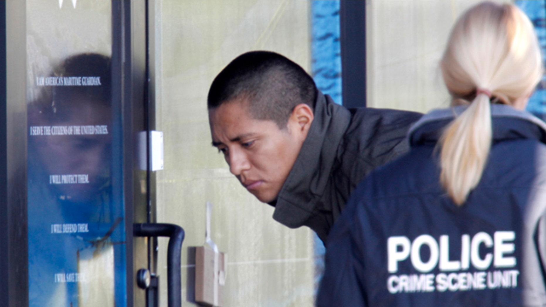 Nov. 2: Law enforcement investigators looks at a door at the Coast Guard recruiting station in Woodbridge, Va.. Police in northern Virginia say shots were fired overnight at a Coast Guard recruiting station, the latest case of someone shooting at military-related buildings in the Washington area. (AP)