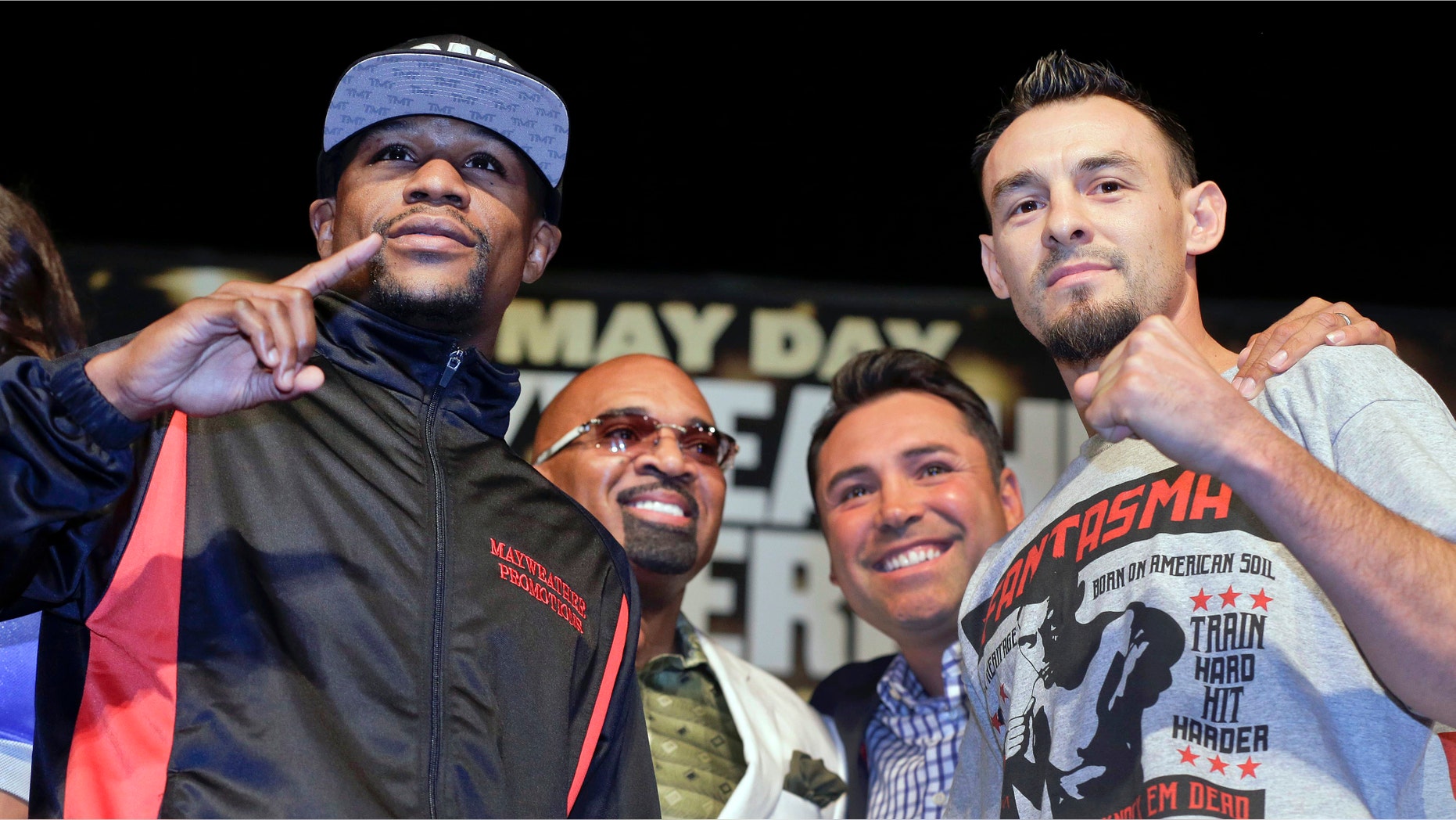 CORRECTS SPELLING TO ELLERBE, INSTEAD OF ELLERBY - Boxers Floyd Mayweather Jr., left, and Robert Guerrero, right, pose for photographers with Mayweather's adviser, Leonard Ellerbe, second from left, and Oscar De La Hoya, during a news conference, Wednesday, May 1, 2013, in Las Vegas. Guerrero will take on Mayweather for Mayweather's WBC welterweight title on Saturday. (AP Photo/Julie Jacobson)