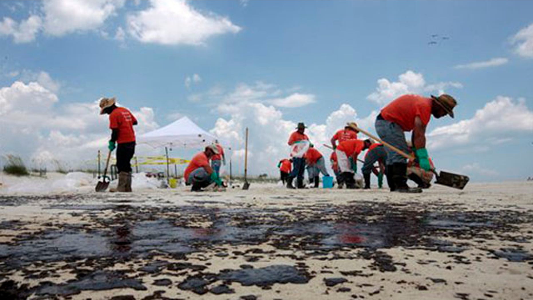 Oil cleanup workers hired by BP pick up oil on the beach in Gulf Shores, Ala., July 2. (AP Photo)
