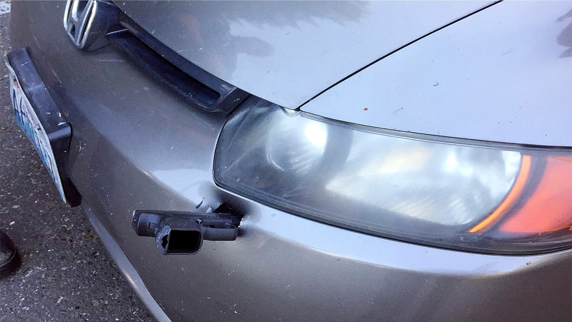 A driver in Washington state found a gun lodged in the front of his car, authorities said.