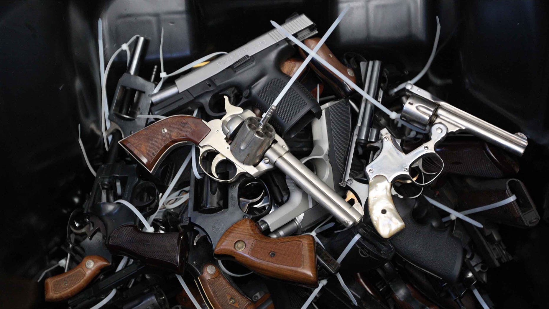 LOS ANGELES, CA - MAY 31: Surrendered handguns are piled in a bin during a gun buyback event that was announced by Los Angeles Mayor Eric Garcetti in the wake of a killing spree at University of California, Santa Barbara that left six students dead, on May 31, 2014 in Los Angeles, California. People can exchange their firearms with no questions asked at four Los Angles-area locations for Ralphs supermarket gift cards ranging from $100 to $200 per weapon. The buyback program first took place in Los Angles in 2009 as part of the Gang Reduction and Youth Development program to reduce the number of guns on the streets. The last buyback resulted in more than 1,500 firearms being turned in. (Photo by David McNew/Getty Images)
