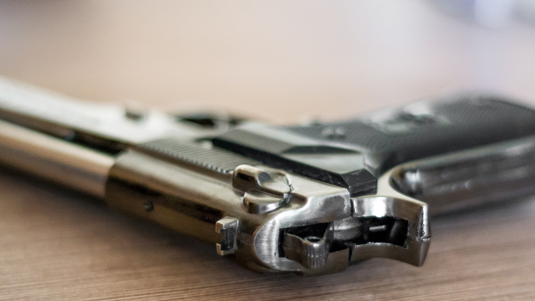 handgun on the wooden surface, closeup, useful for various security,protection or criminal topics
