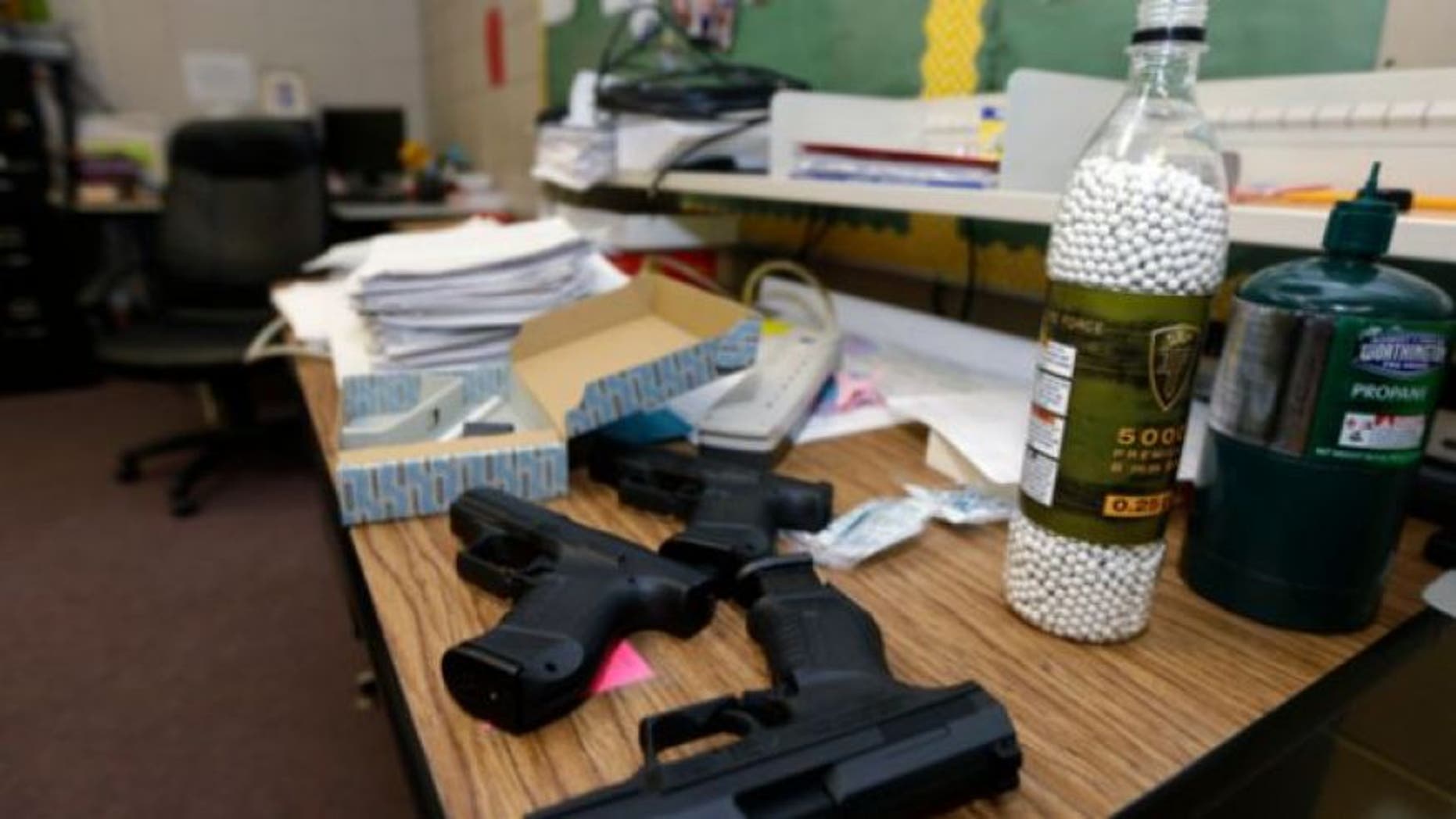 FILE: July 11, 2013: Practice air-powered handguns sit on a teacher's desk in a classroom at Clarksville High School in Clarksville, Ark.
