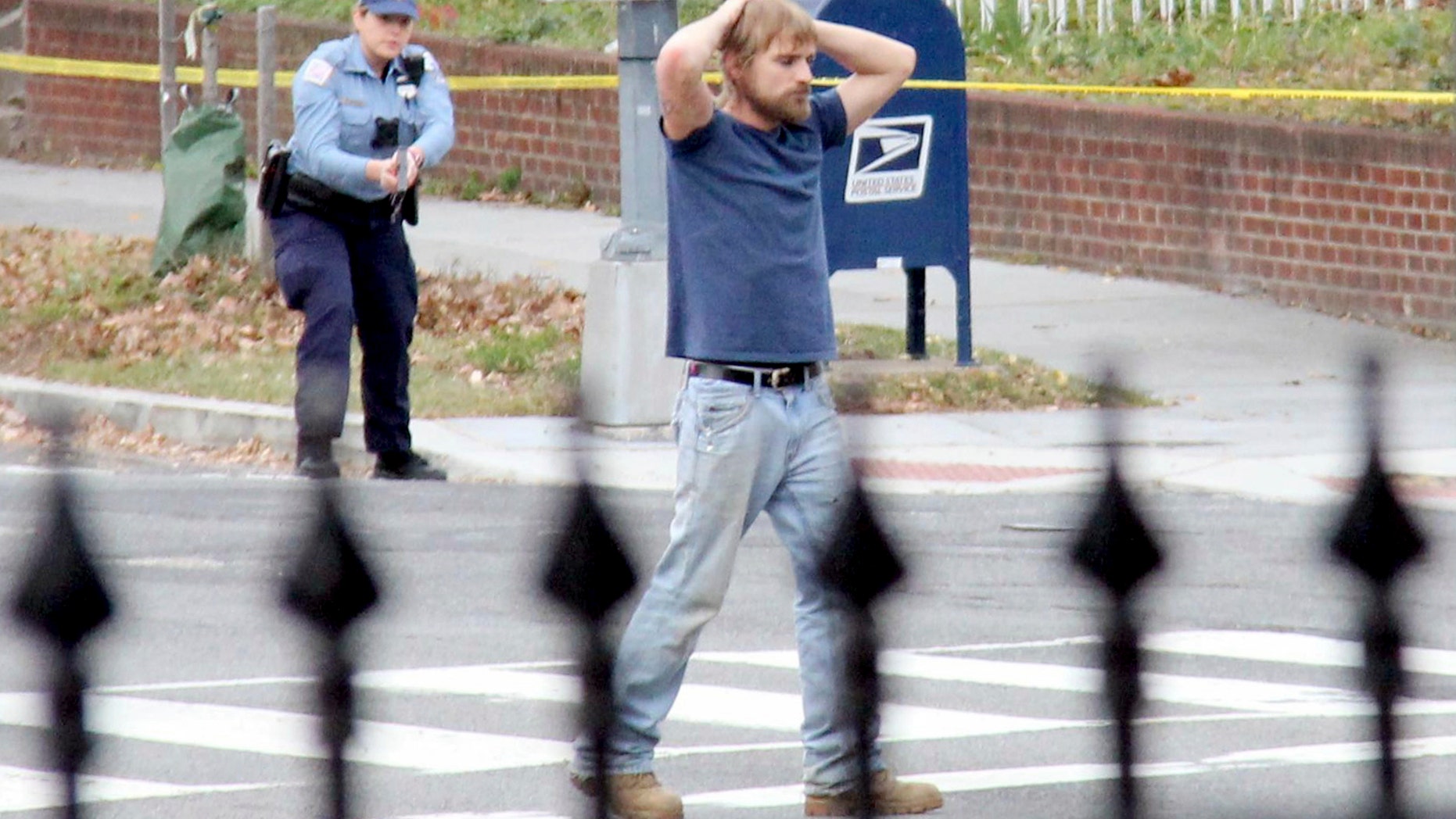 Edgar Maddison Welch, 28 of Salisbury, N.C., surrenders to police Sunday, Dec. 4, 2016, in Washington. Welch, who said he was investigating a conspiracy theory about Hillary Clinton running a child sex ring out of a pizza place, fired an assault rifle inside the restaurant on Sunday injuring no one, police and news reports said. (Sathi Soma via AP)