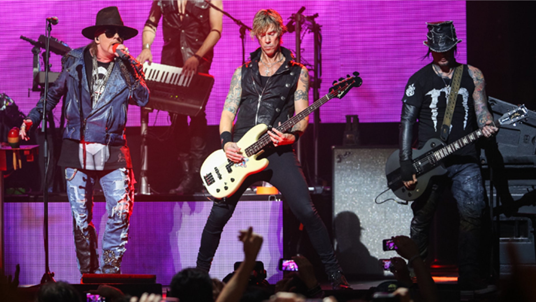 April 23, 2014 file photo, Axl Rose, from left, Duff McKagan and DJ Ashba of Guns N' Roses perform in Los Angeles.