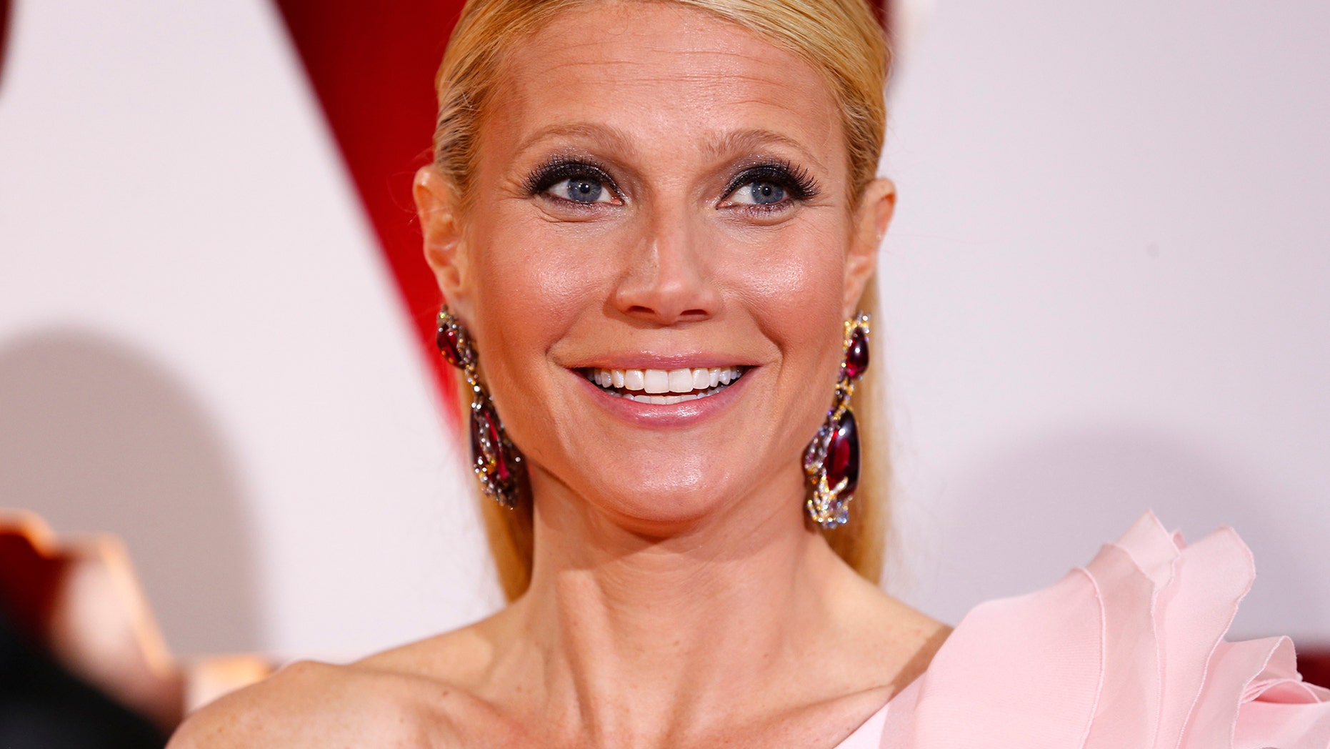 Actress Gwyneth Paltrow, wearing a custom Ralph & Russo pink one sleeve gown with a giant flower on the shoulder, arrives at the 87th Academy Awards in Hollywood, California February 22, 2015.