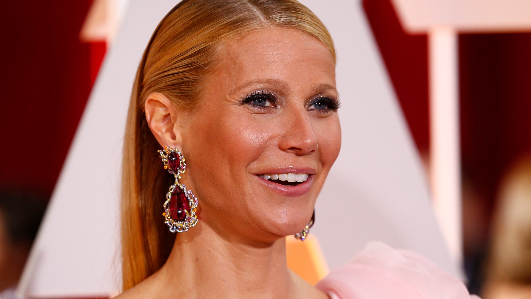 Actress Gwyneth Paltrow, wearing a custom Ralph & Russo pink one sleeve gown with a giant flower on the shoulder, arrives at the 87th Academy Awards in Hollywood, California February 22, 2015.