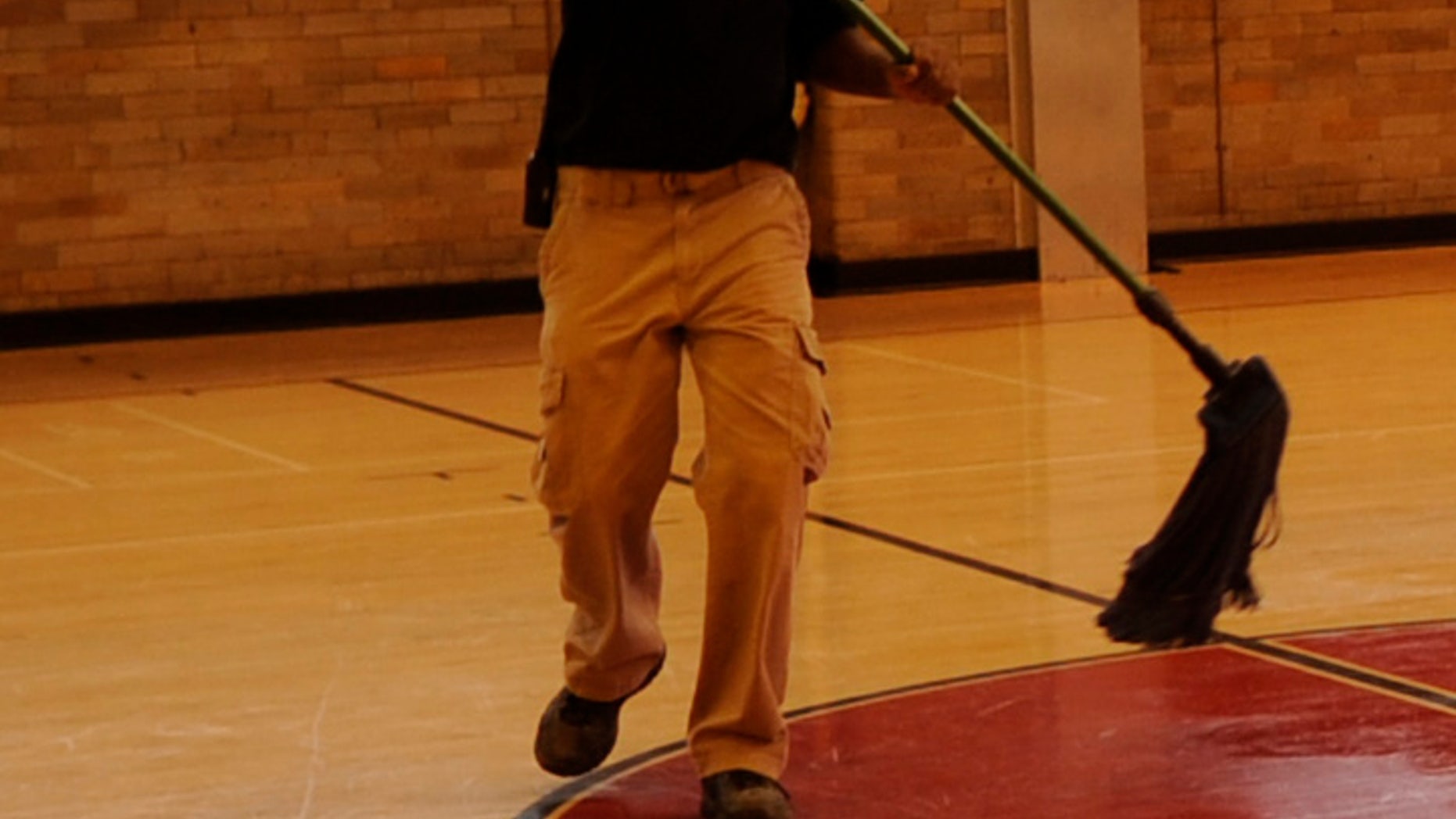 Lafayette Rockette, facility manager at East High School, cleans the floor, Monday, November 06, 2011, in the Calloway Gym at East High School that was built in 1924. RJ Sangosti, The Denver Post