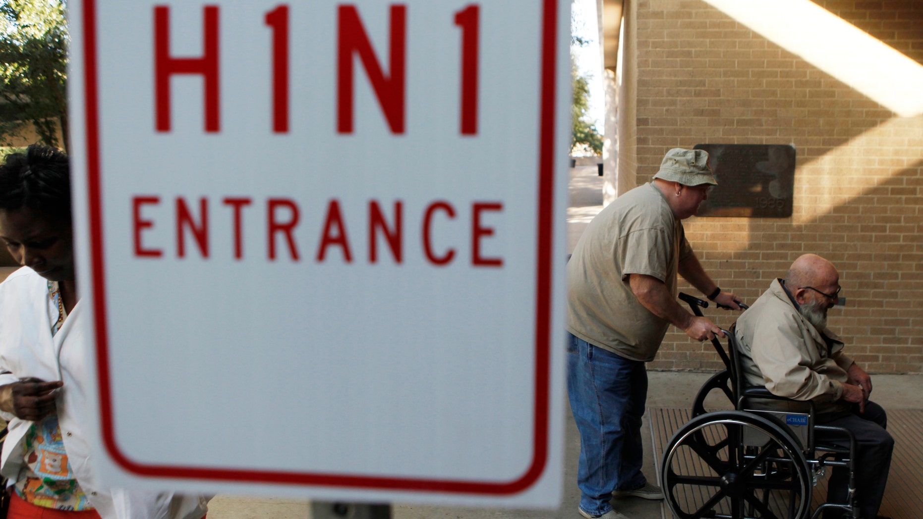 Men enter the Arlington Convention Center to receive their H1N1 flu vaccinations in Arlington, Texas November 24, 2009. (REUTERS/Jessica Rinaldi)