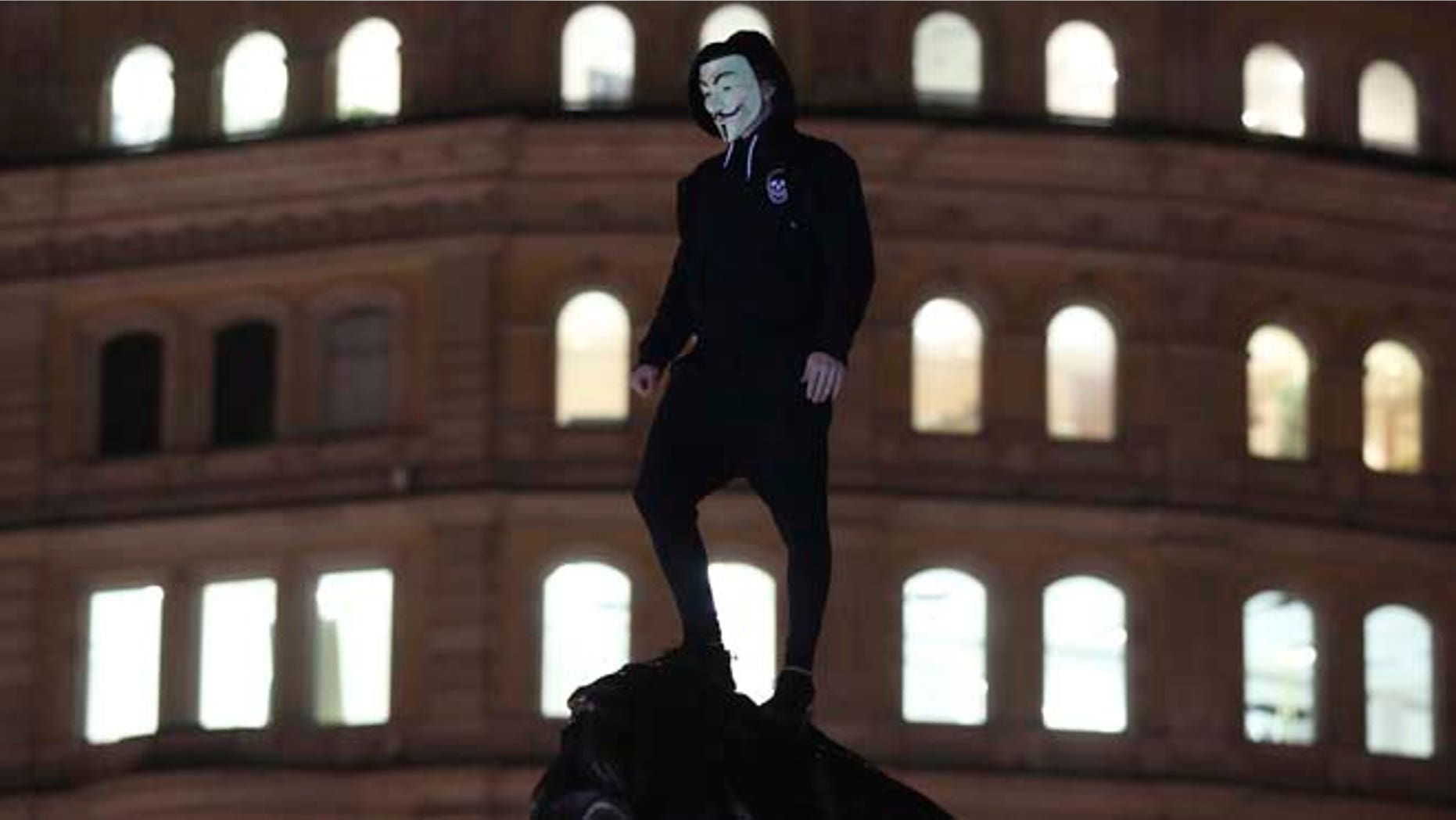 FILE 1014: A protester stands in Trafalgar Square as thousands gathered in central London for the annual bonfire night protest led by the hacktivist collective Anonymous.