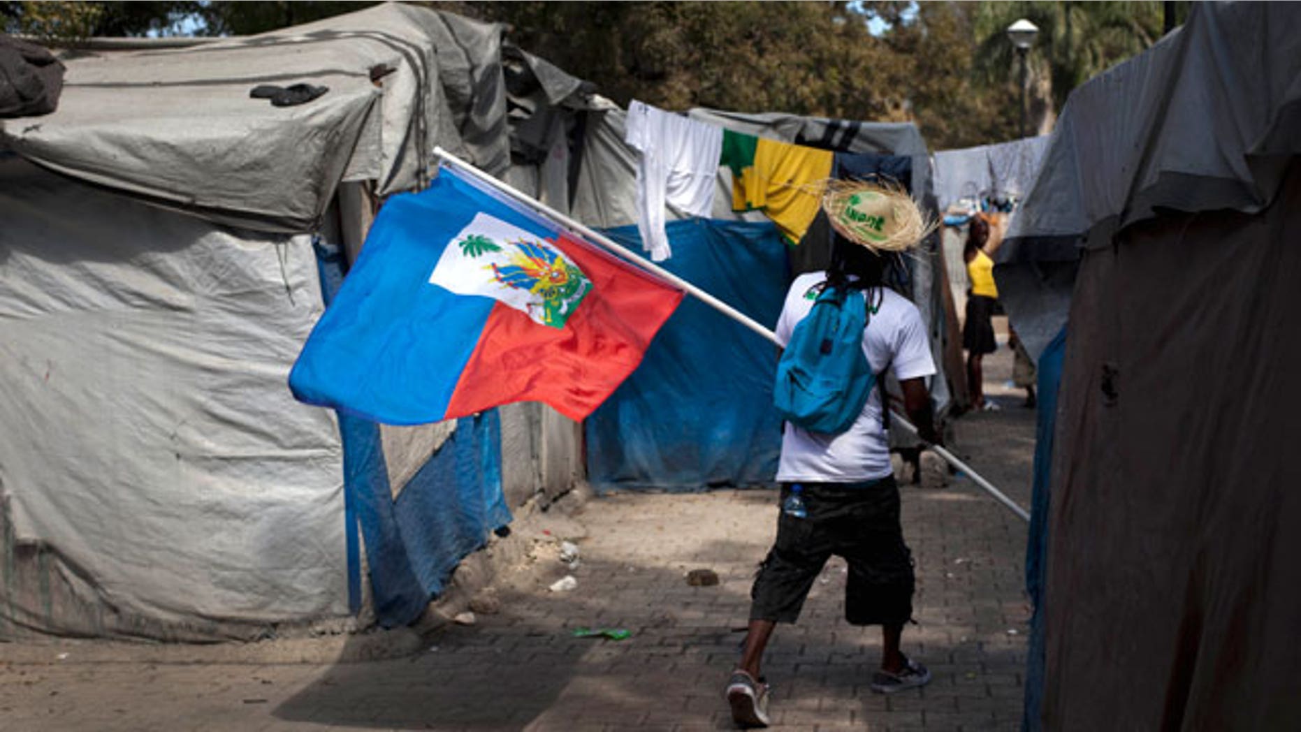 Jan. 11, 2012: A demonstrator carrying a Haitian flag walks through the Champ de Mars camp, across the street from the collapsed National Palace, during a protest to demand new housing, in Port-au-Prince, Haiti.