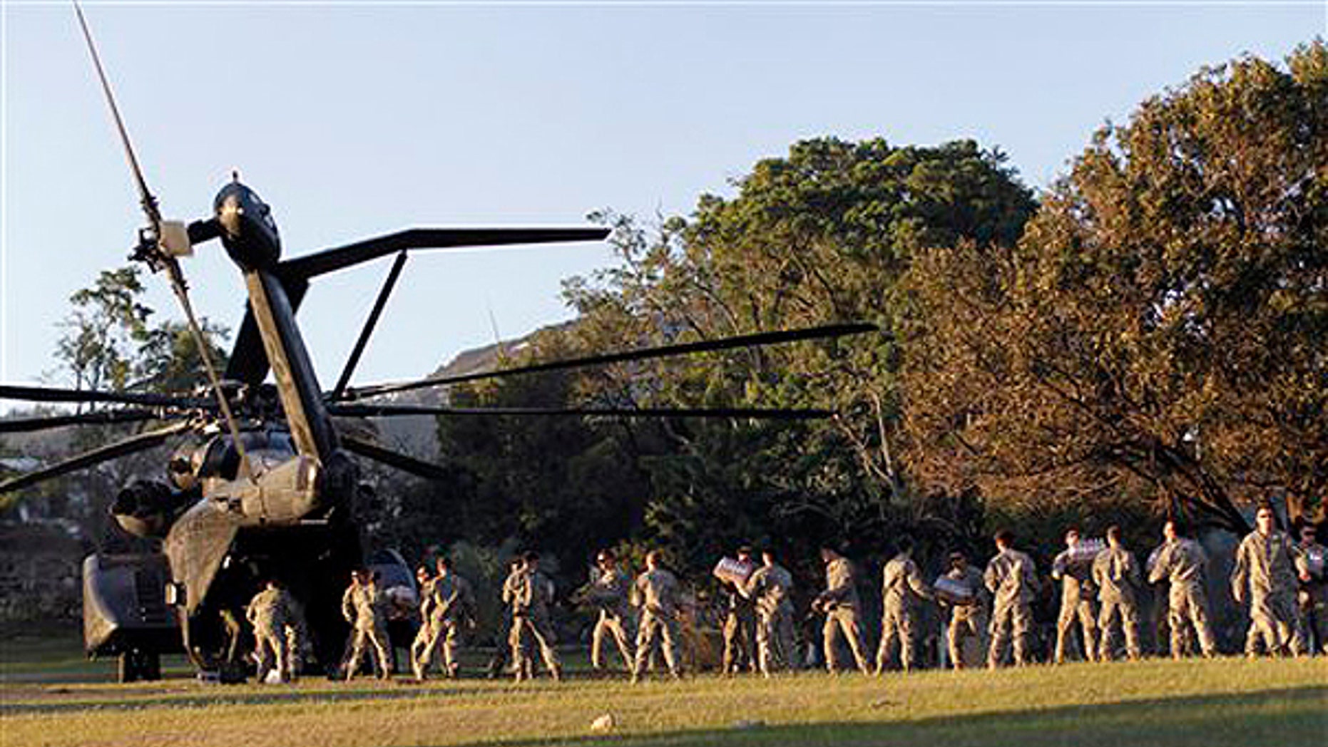 Monday: U.S. troops with the 82nd Airborne Division unload disaster relief supplies in Port-au-Prince. Troops, doctors and aid workers flowed into Haiti on Monday even while hundreds of thousands of Tuesday's quake victims struggled to find water or food. (AP Photo)
