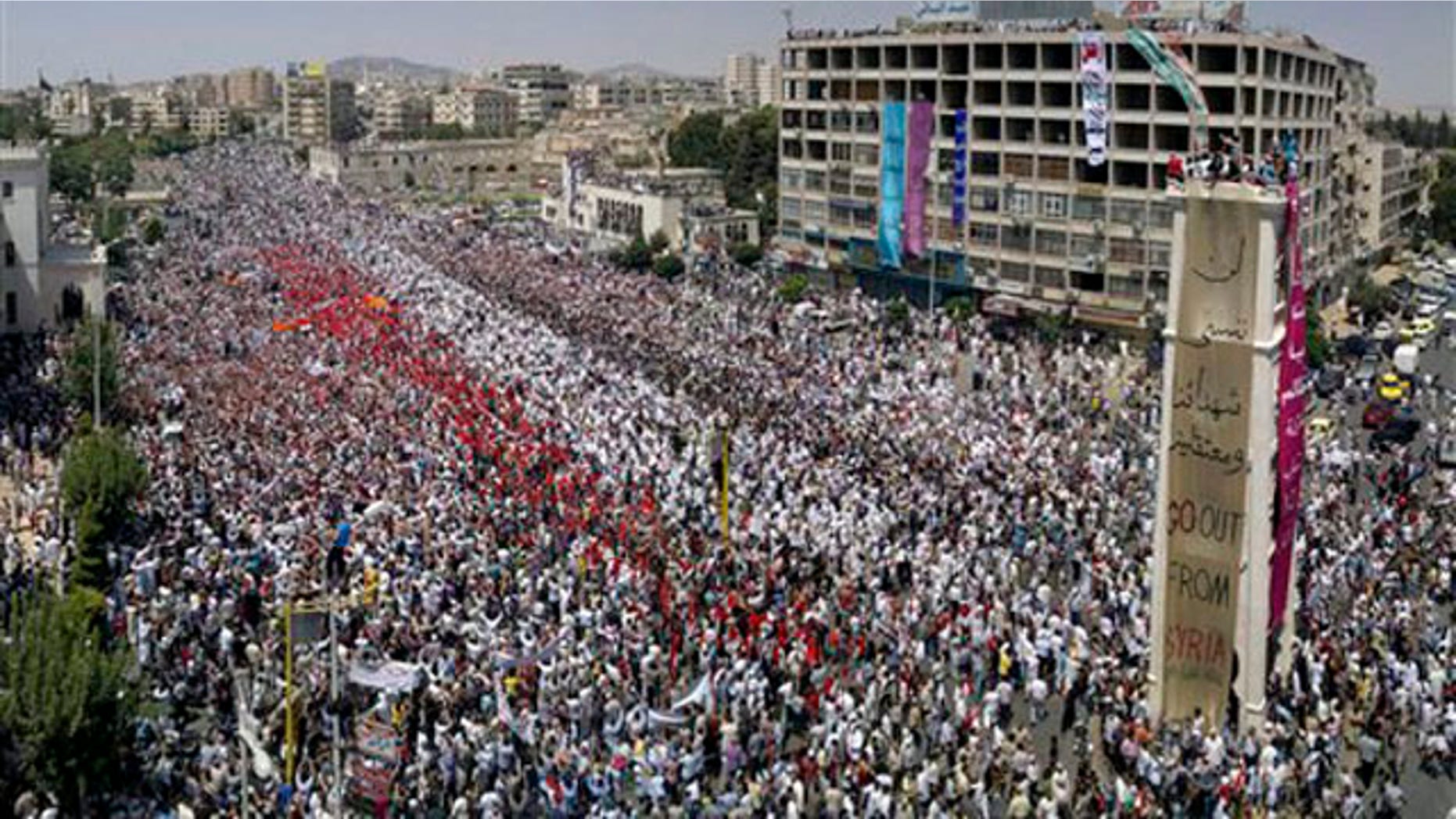 A citizen journalism image made July 22 on a mobile phone and provided by Shaam News Network shows Syrian anti-regime protesters gather during a rally in al-Assy square in the western city of Hama, Syria.