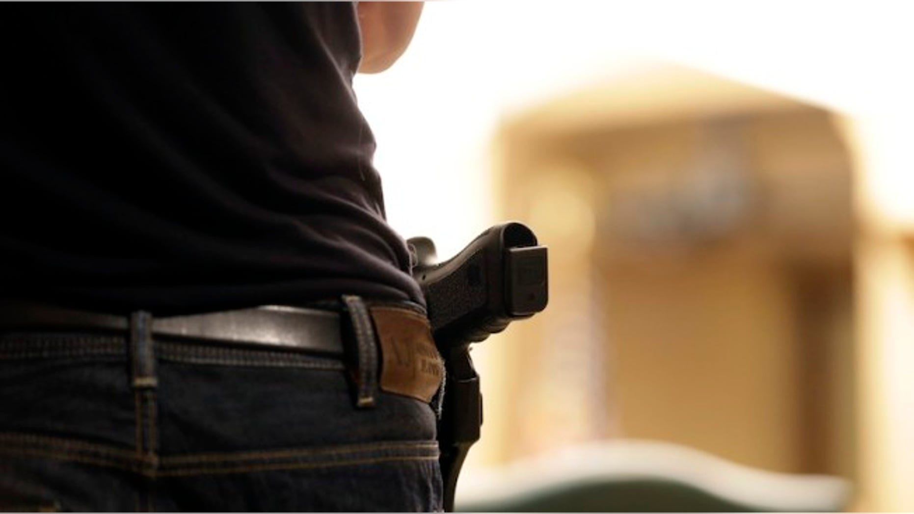A Glock handgun is holstered on the side of Kristopher Kranz of Bloomington, Minn., as he listens during public testimony Tuesday, Aug. 20, 2013 in St. Paul, Minn. in front of a panel studying whether Minnesota's rules for carrying a gun in the Capitol need revising, (AP Photo/Jim Mone)