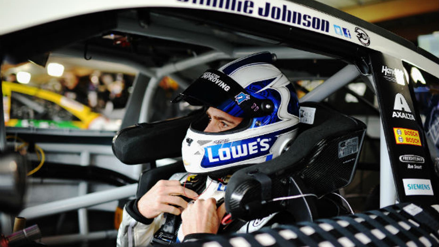 Jimmie Johnson, six-time NASCAR Sprint Cup Series champion and driver of the #48 Lowe's Chevrolet, sits in his car during practice for the NASCAR Sprint Cup Series STP 500 at Martinsville Speedway on March 28, 2014 in Martinsville, Virginia. The HANS device is the collar attached to the helmet via tether; it is also secured to the shoulder harness and seat. (Photo by Rainier Ehrhardt/NASCAR via Getty Images)