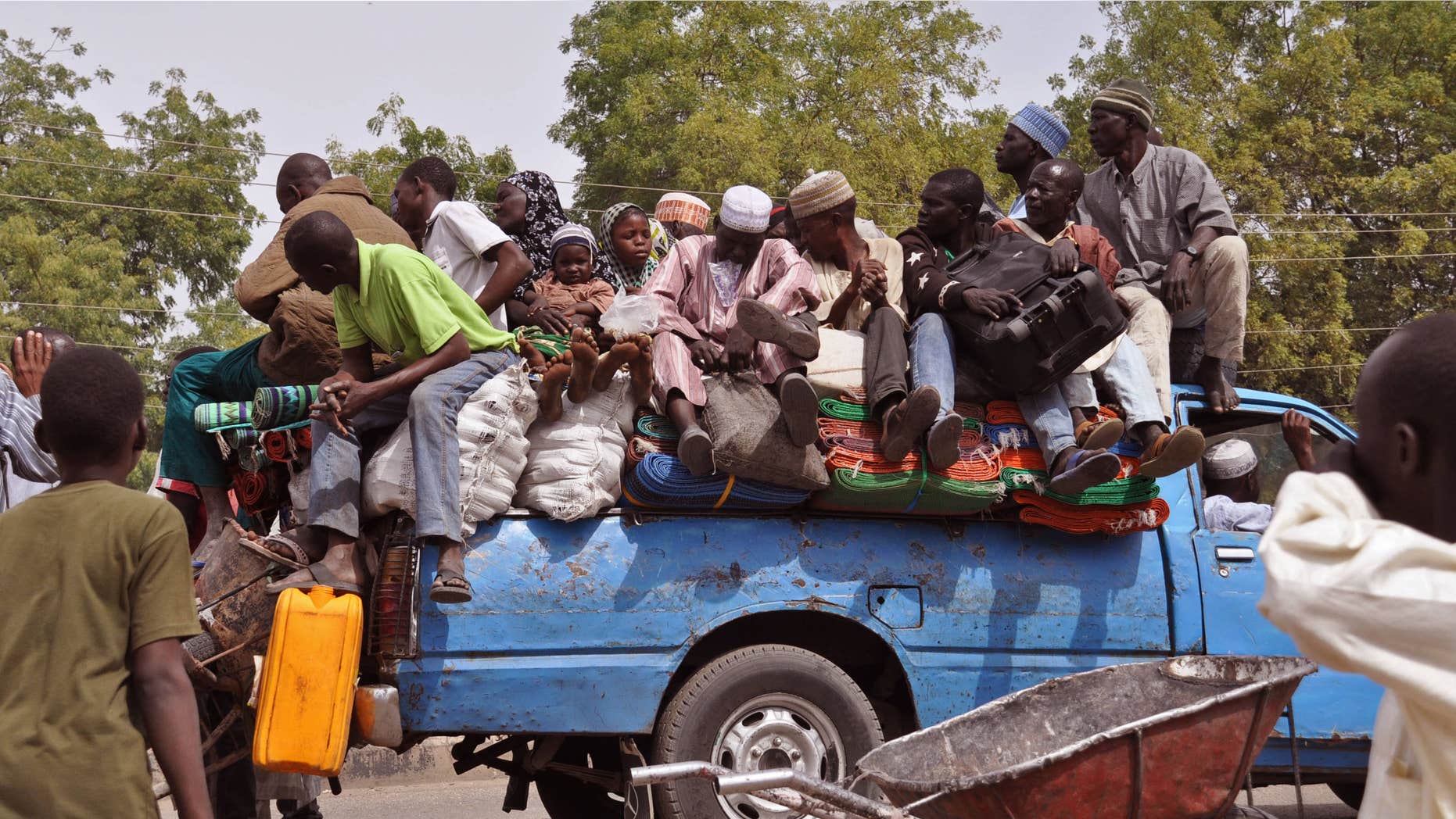 Jan. 27, 2015: villagers sit on the back of a small truck as they and others flee the recent violence near the city of Maiduguri, Nigeria.