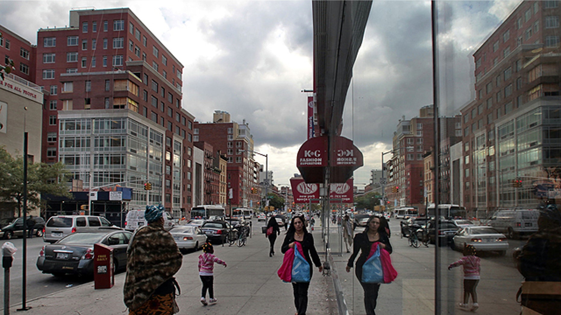 This Oct. 6, 2010 photo shows a new red brick hi-rise, left, an ongoing construction project which will house the new Aloft Hotel and condominiums in Harlem, is reflected in the windows of the Magic Johnson theater building in New York.