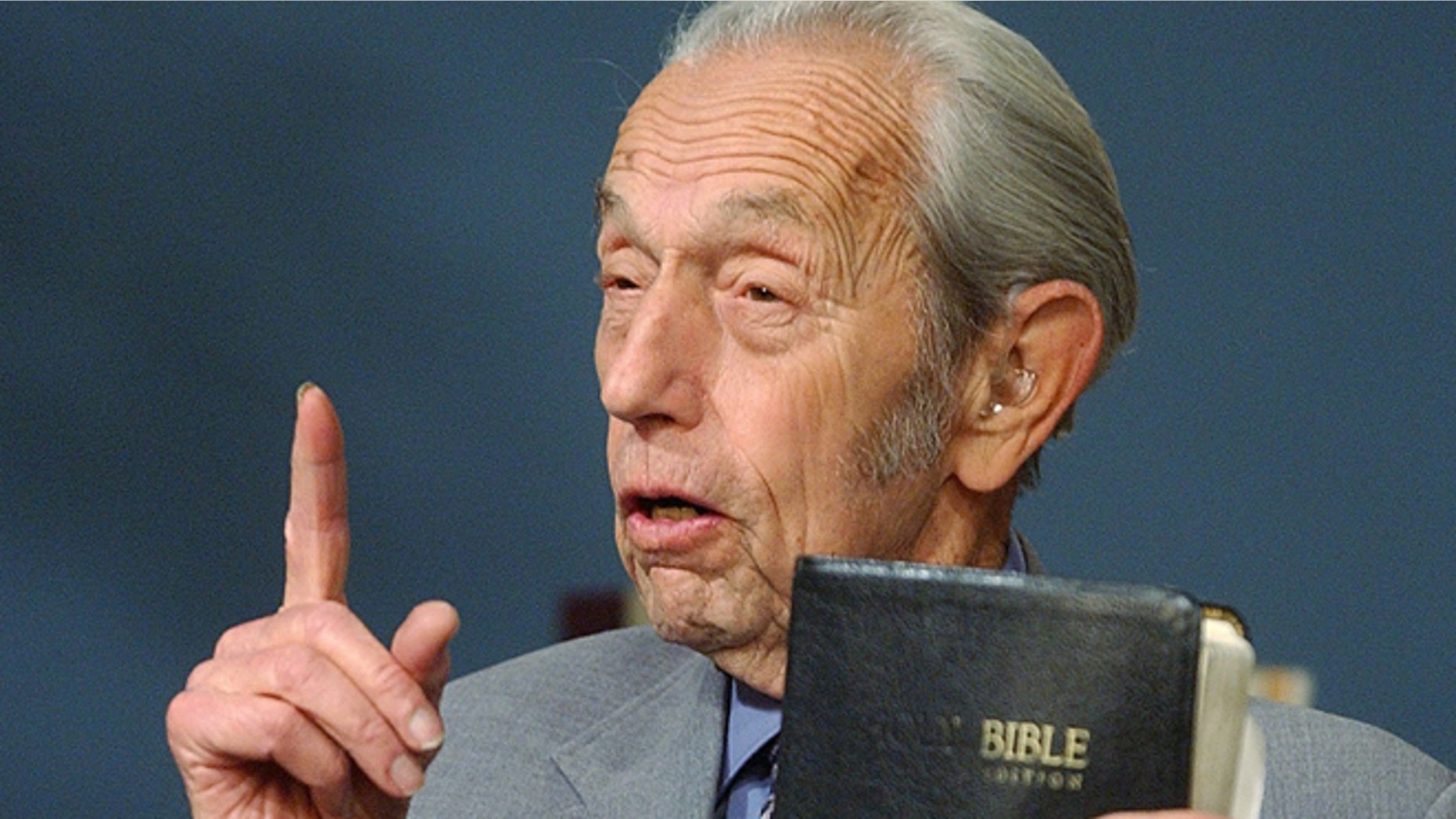 In this Dec. 12, 2002 file photo, Harold Camping holds a Bible as he speaks during his live television broadcast in San Leandro, Calif. Camping, who used his evangelical ministry and thousands of billboards to broadcast the end of the world and then gave up public prophecy when his date-specific doomsdays did not come to pass, has died at age 92. Camping died at his home Sunday, Dec. 15, 2013 according to Family Radio Network marketing manager Nina Romero. She said he had been hospitalized after falling.