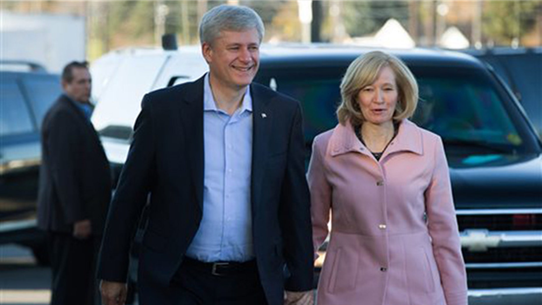 Conservative Leader, Prime Minister Stephen Harper, left, and his wife Laureen arrive to cast their ballots in the federal election in Calgary, Alberta, on Monday, Oct. 19, 2015. Canadians voted Monday to decide whether to extend Harper's near-decade in power or return Canada to its more liberal roots. (Darryl Dyck/The Canadian Press via AP) MANDATORY CREDIT