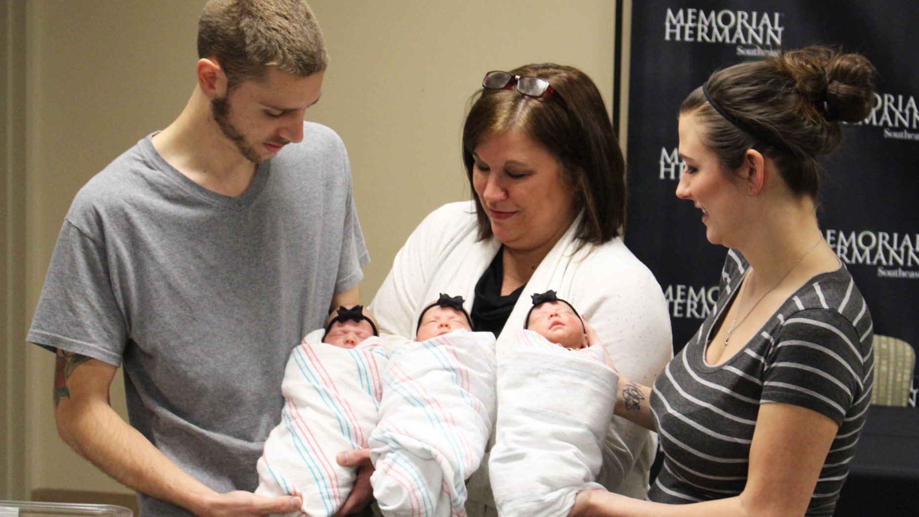 Proud Parents Brad and Stephanie Harris and grandmother Lynn Sweat holding (from left to right) identical triplets Savannah, Addison and Kinsley Harris.