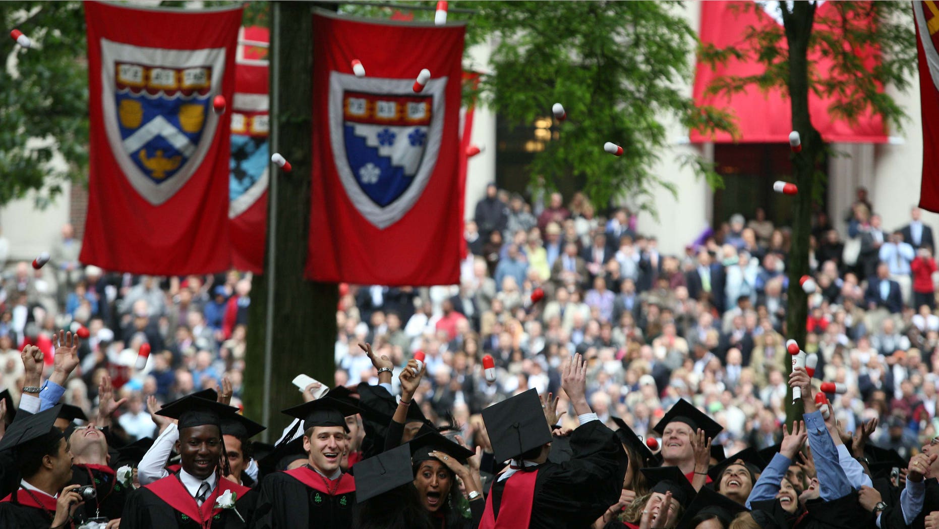 Harvard University Medical School graduates celebrate at commencement ceremonies by tossing giant pills in the air.