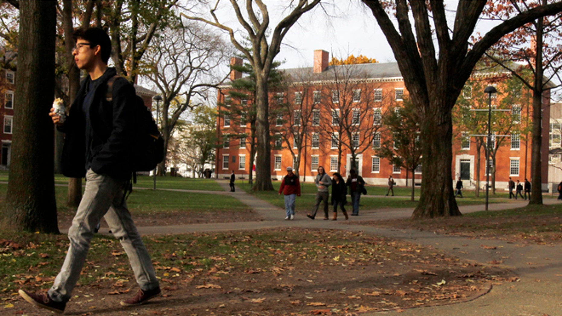 FILE 2012: A man walks through Harvard Yard at Harvard University. A recent survey suggests that getting into an elite school may not produce happier people.