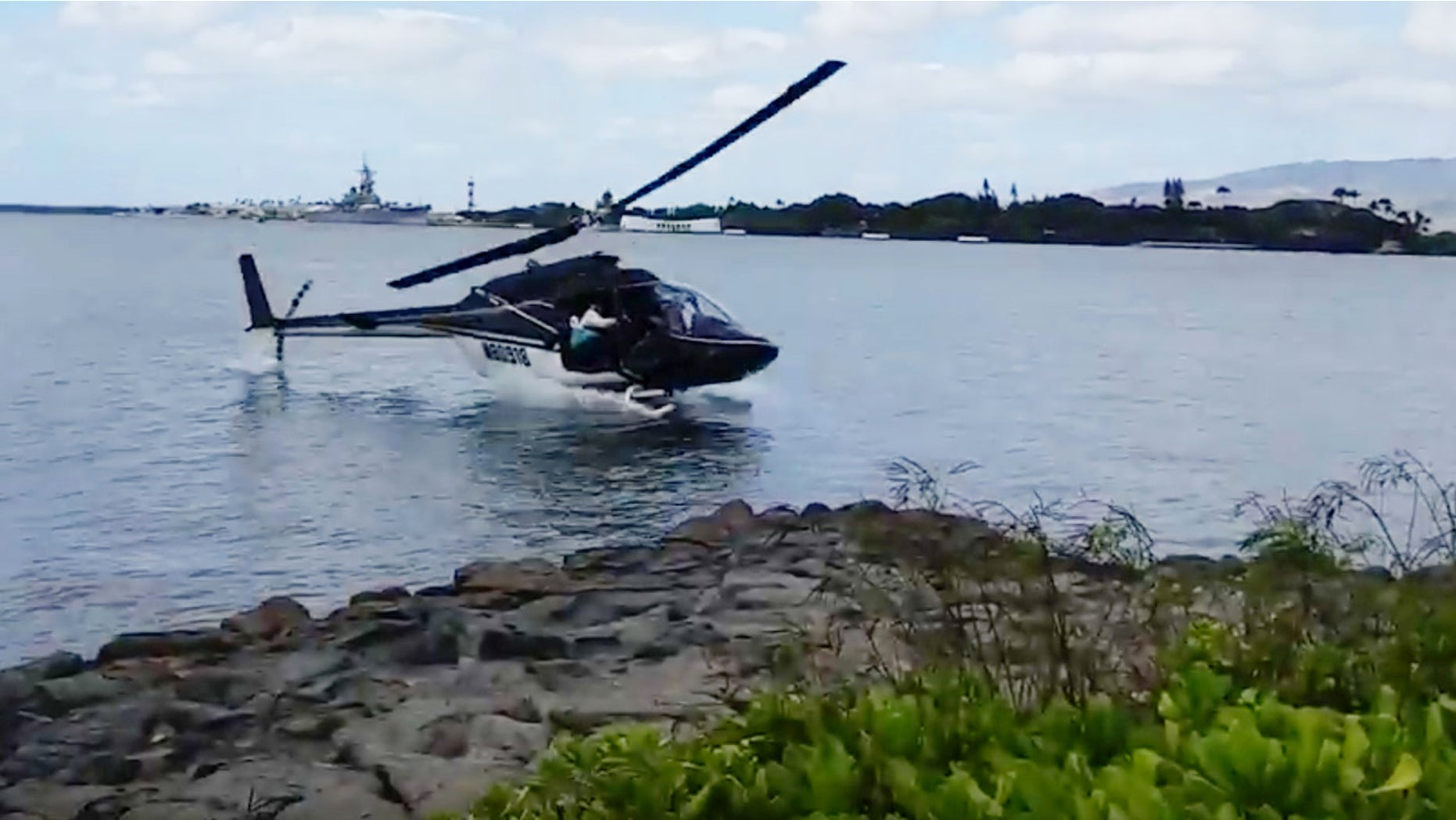 Feb. 18, 2016: In this image taken from video provided by Shawn Winrich, a helicopter crashes near Parl Harbor, Hawaii (Shawn Winrich via the AP)