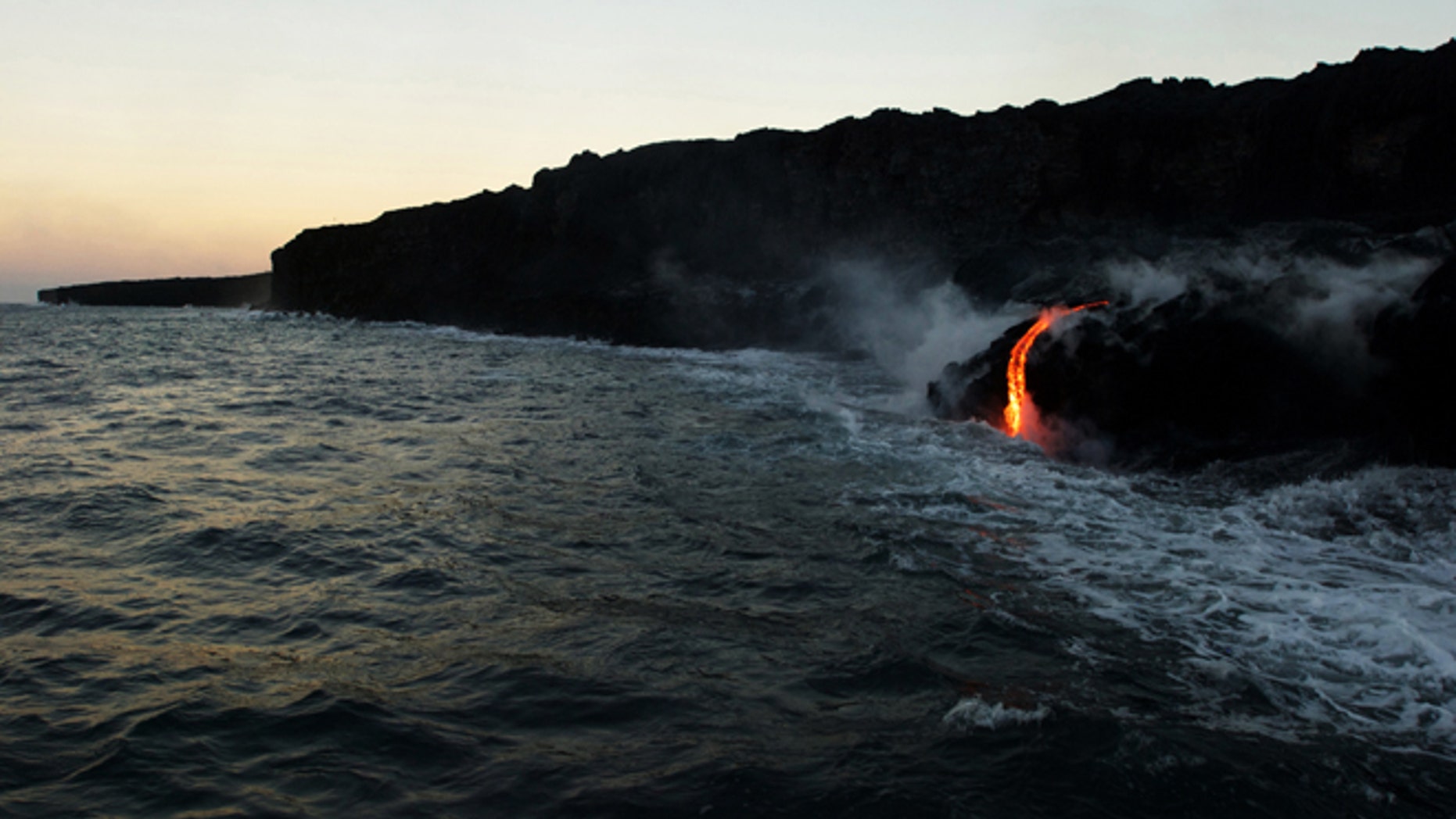 In this Tuesday, Aug. 9, 2016 photo, lava from Kilauea, an active volcano on Hawaii's Big Island, flows into the ocean as seen from a boat operated by Lava Ocean Tours off the coast of Volcanoes National Park near Kalapana, Hawaii.