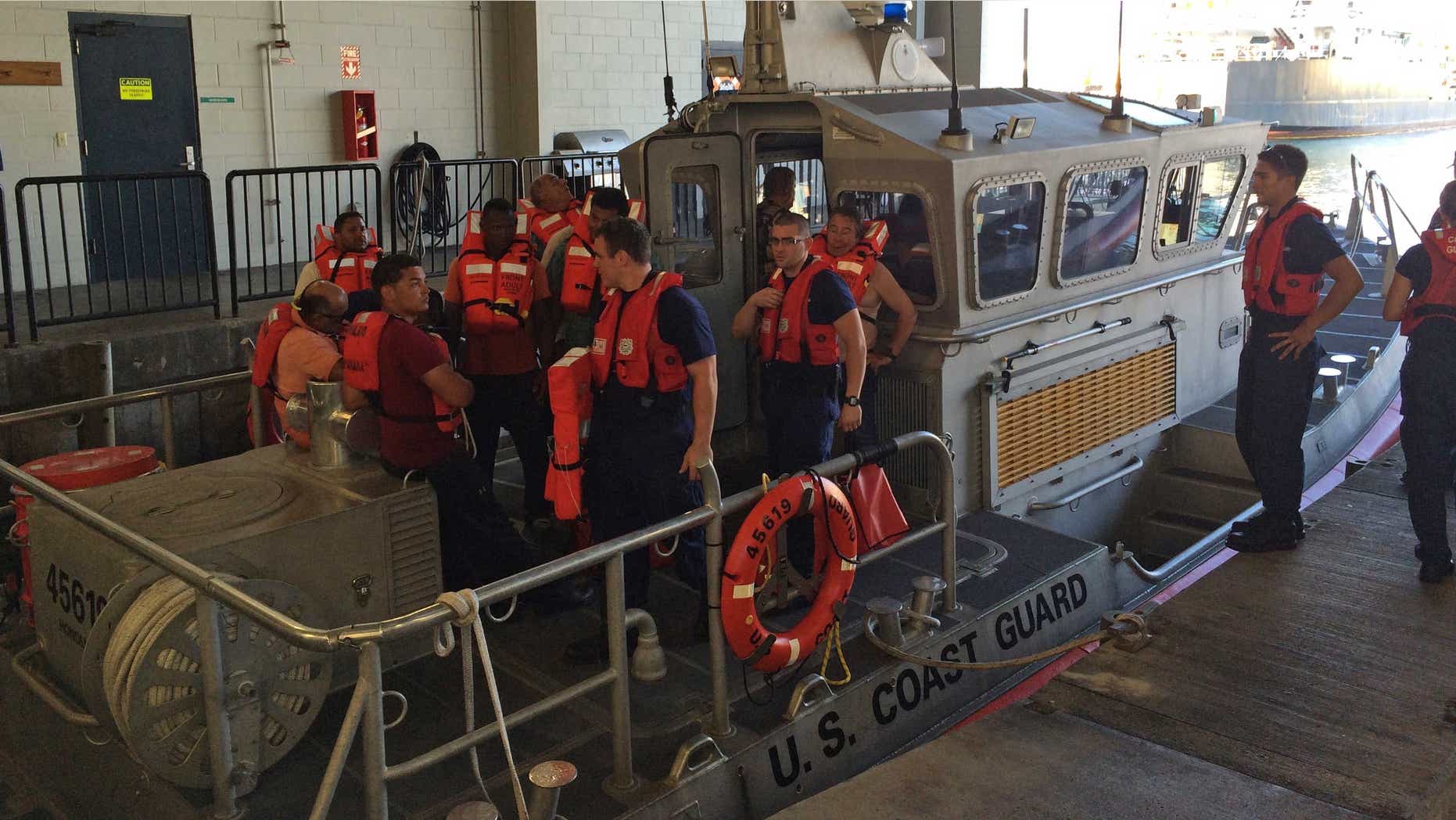 Jan. 22, 2015: Coast Guard crew members standing with 11 survivors of the Tug Nalani at Coast Guard Station Honolulu.