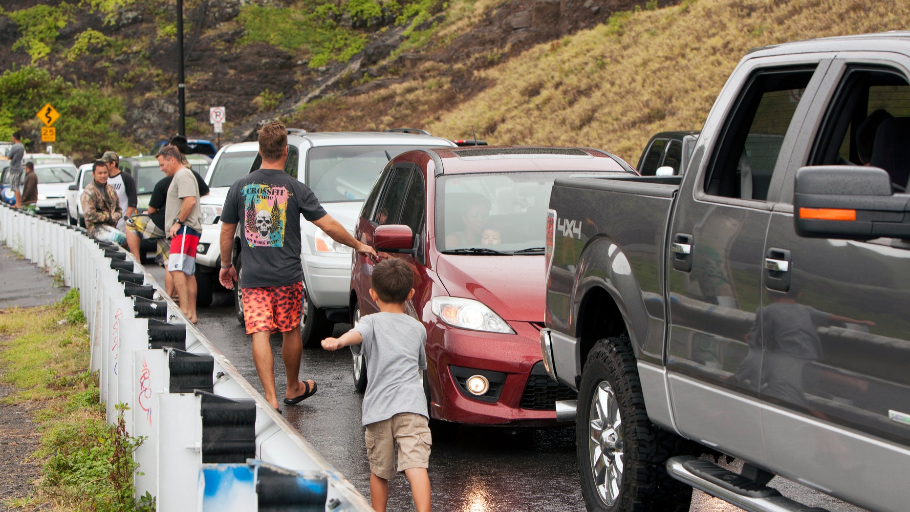 Aug. 8, 2014: Onlookers park on the side of the road to look at the waves at Makapuu Beach in Waimanalo, Hawaii.