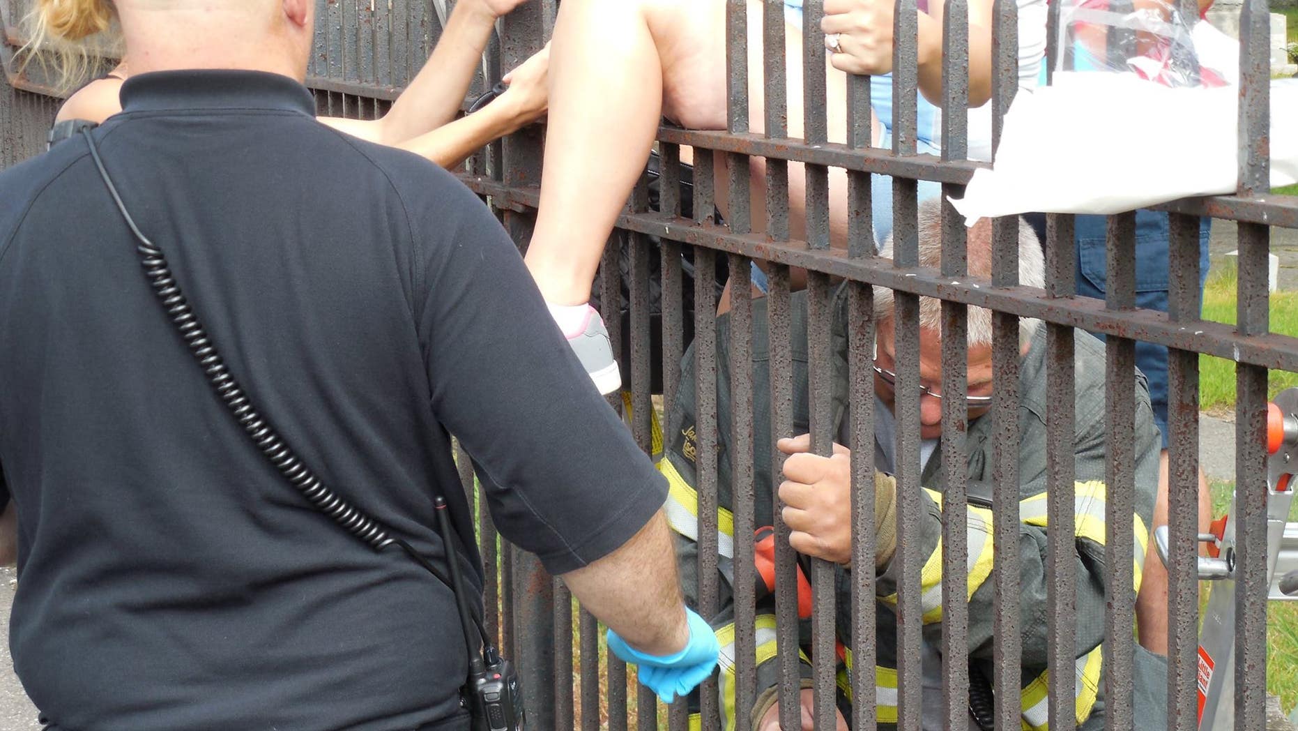 July 22, 2014: Rescue personnel work to free a woman impaled on a Pennsylvania cemetery fence.